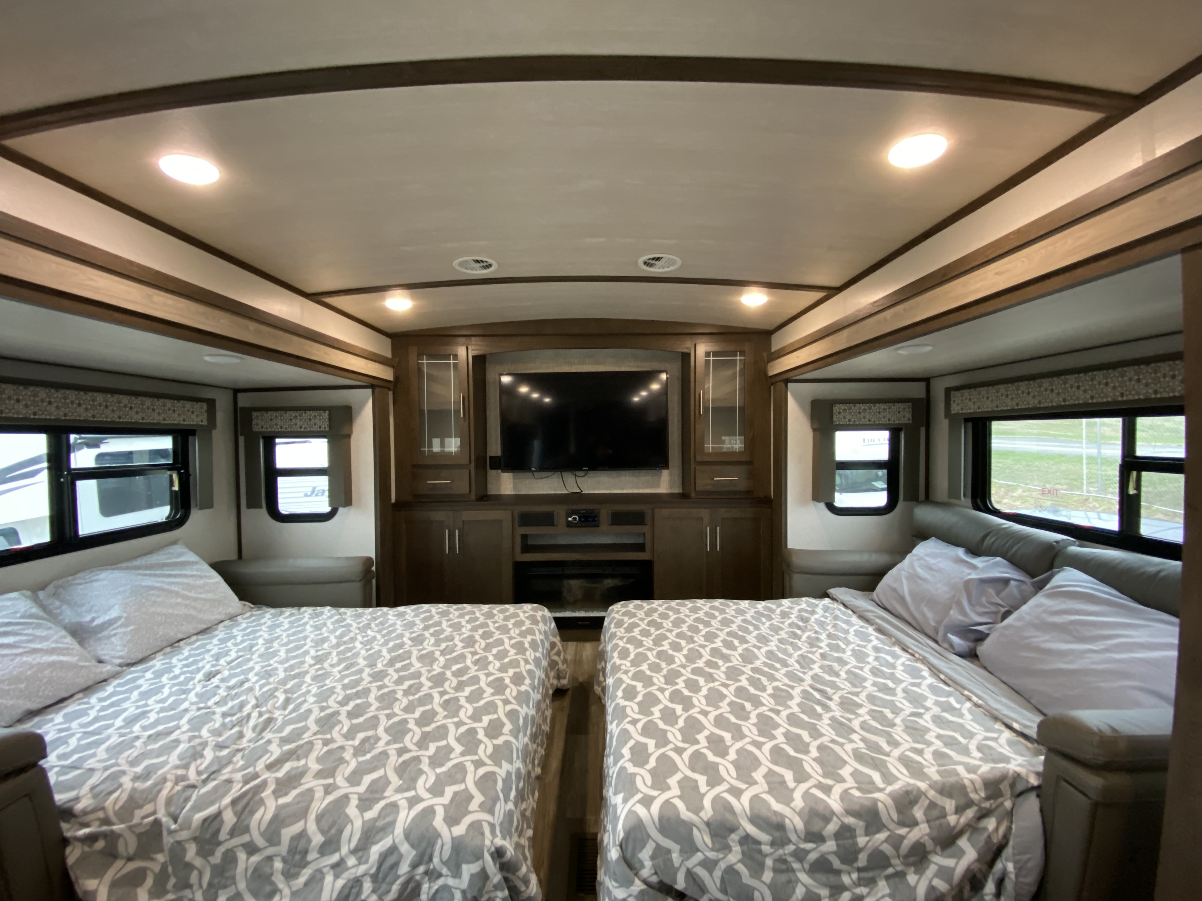 Spacious RV interior featuring two comfy beds, a large TV console, and windows on both sides, perfect for your next rv rental.. Forest River Salem Hemisphere 2020