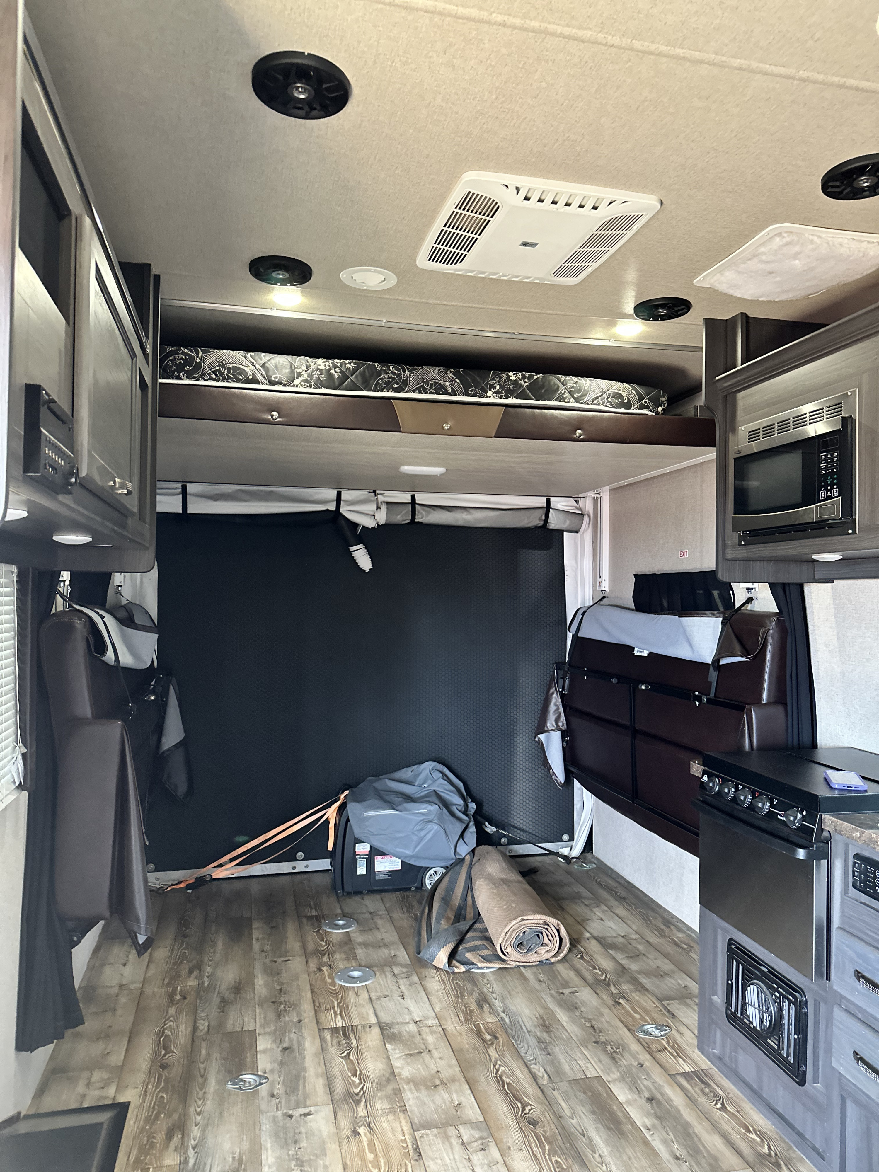 RV rental with versatile interior, featuring upper bunk, kitchen, and open cargo space with tie-downs.. genesis supreme genesis 2017