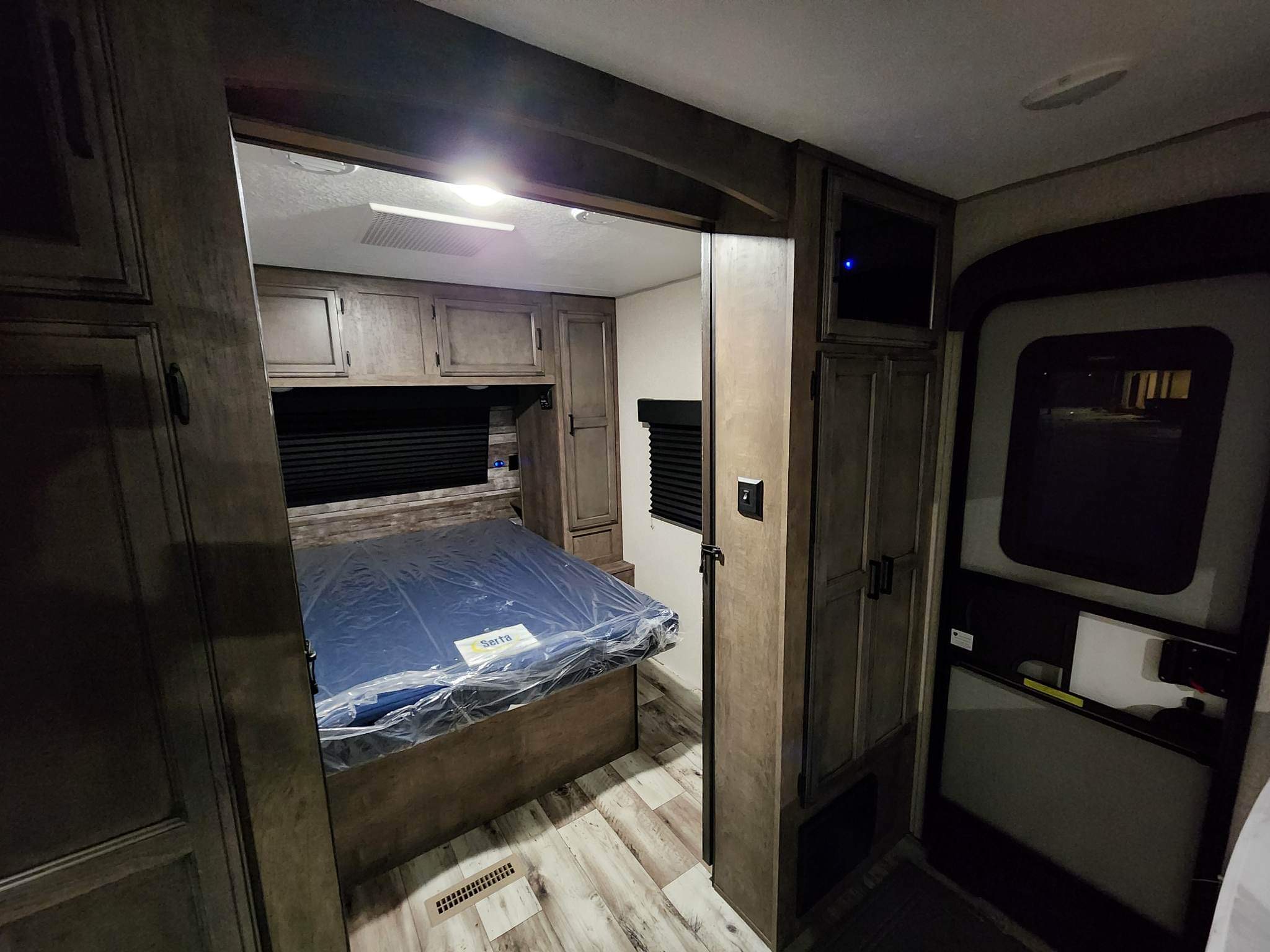 This inviting RV rental bedroom features a new Serta mattress, built-in cabinetry, and wood-look flooring.. Venture Sporttrek 2022