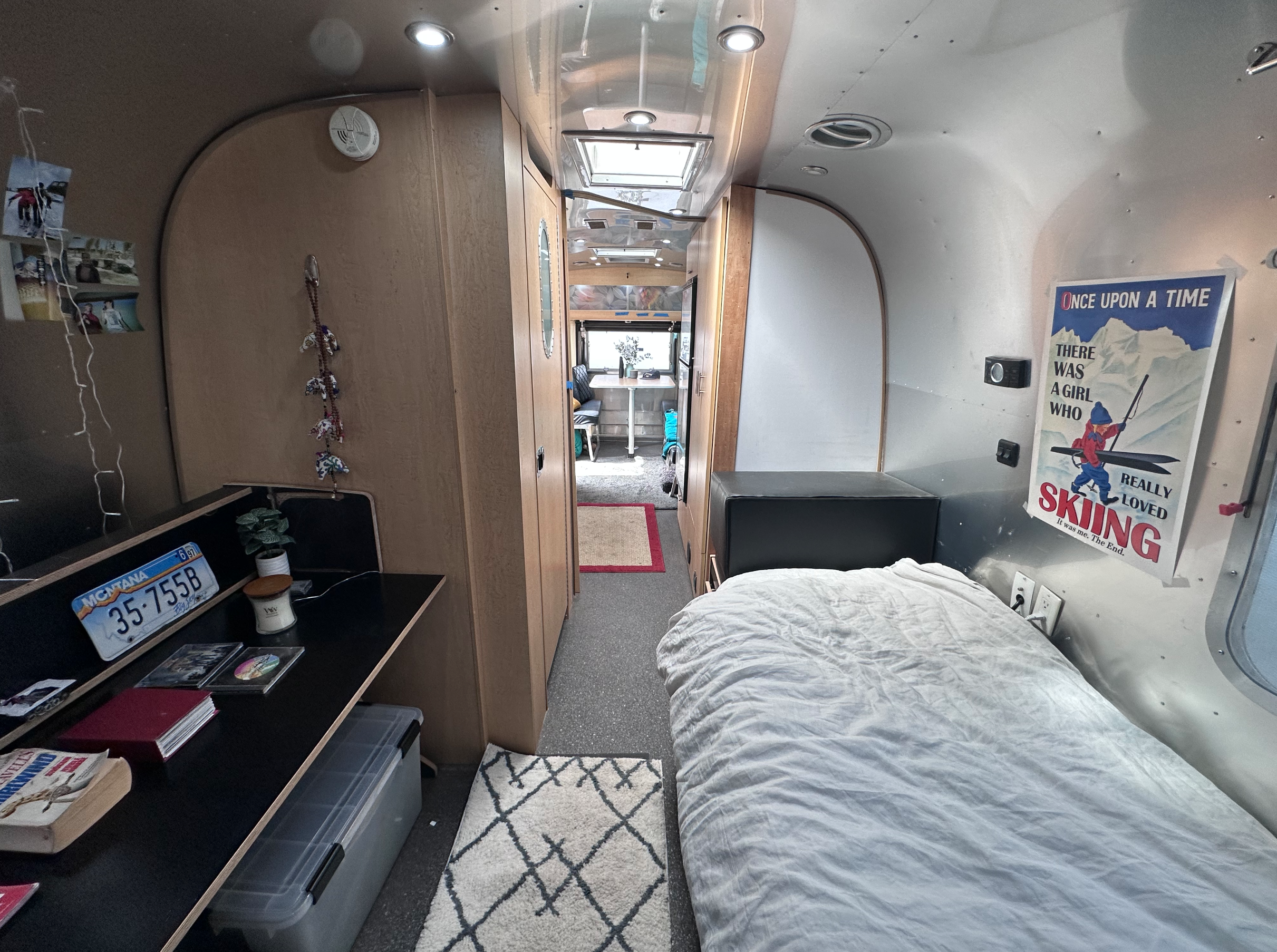 Cozy RV rental interior, showcasing a compact living space with a bed, desk, and amenities for travel and camping.. Airstream Eddie Bauer 2014