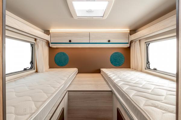 This RV rental interior features comfortable twin beds, overhead storage, and ample natural light, ideal for road trips.. Rimor Kilig 95 Plus 2023