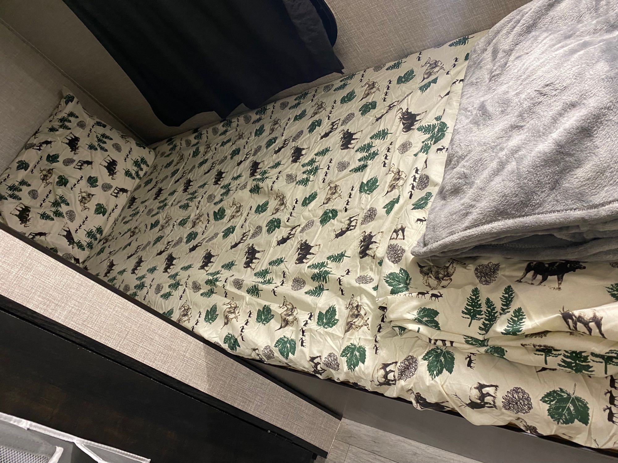 Cozy RV rental bunk bed with nature-themed bedding and soft blanket, perfect for a comfortable night's sleep on the road.. Jayco Jay Flight SLX 2022