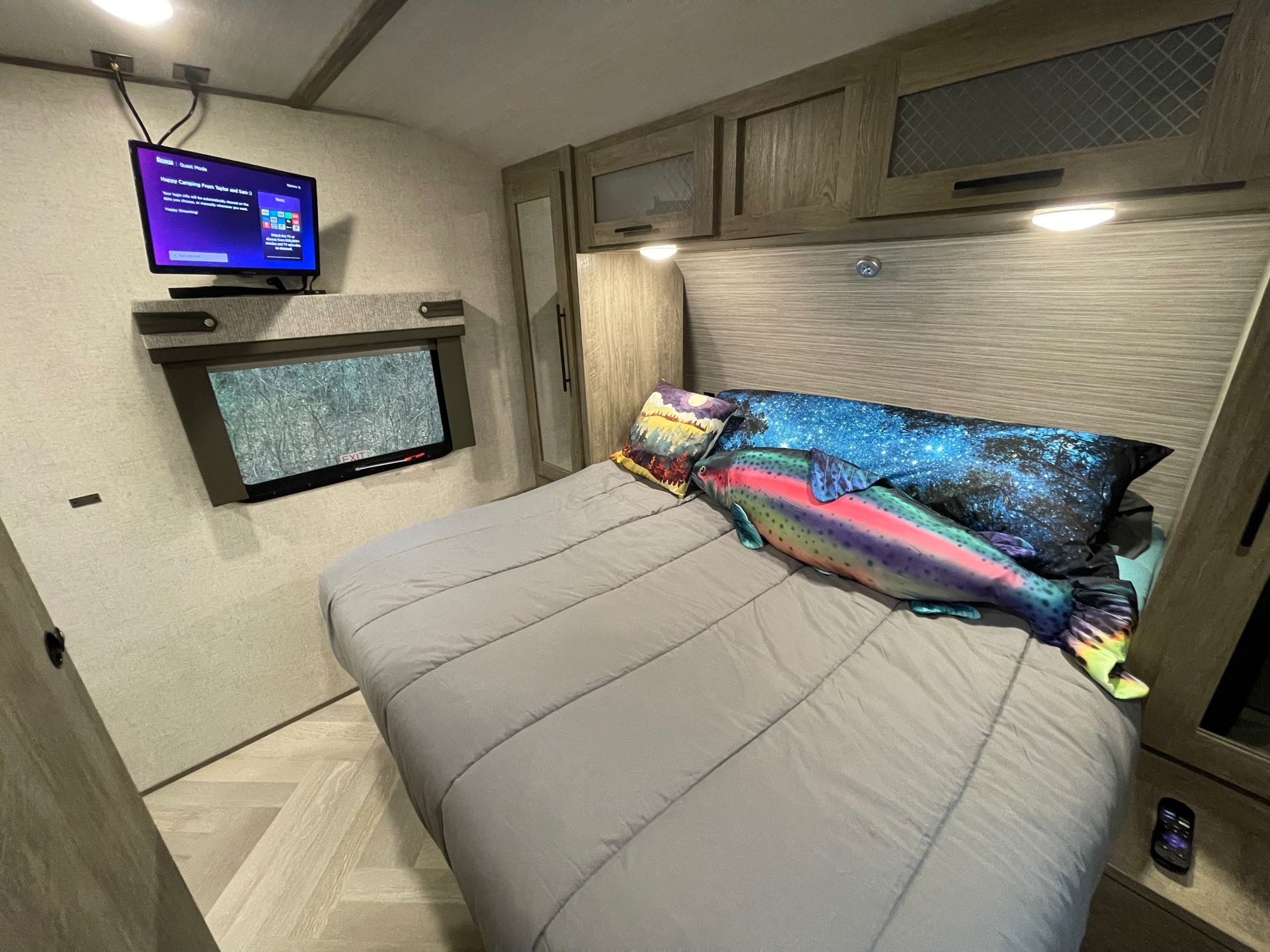 Cozy RV rental bedroom: features a spacious bed with colorful pillows, a wall-mounted TV, and ample storage.. Forest River Salem Hemisphere HL 2021