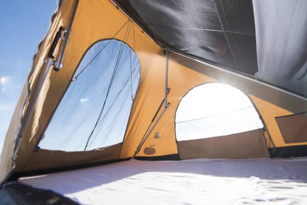 Cozy interior of a rooftop tent for your RV rental adventure, featuring bright views & a comfy bed.. Suzuki Jimny 2023