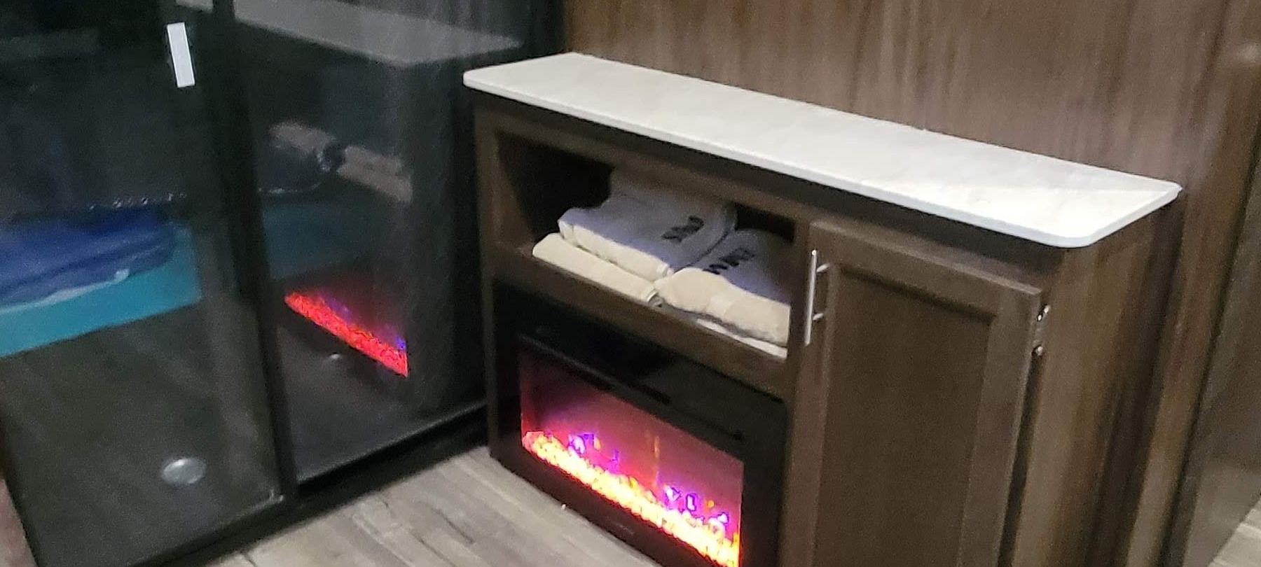 RV rental comfort: Enjoy the warm glow of an electric fireplace, ample storage, and fresh towels in this cozy interior.. Forest River Cherokee Wolf Pack Toy Hauler 2018