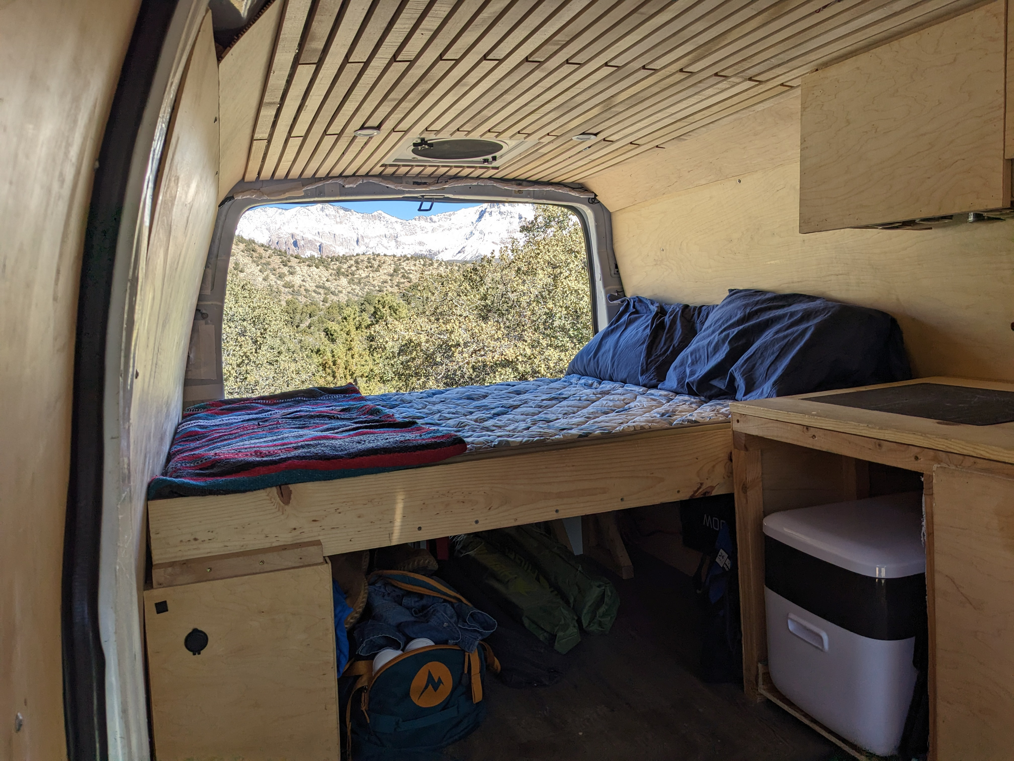 This RV rental features a comfortable bed, under-bed storage, and beautiful mountain views from the back of the camper van.. Chevrolet Express 2011
