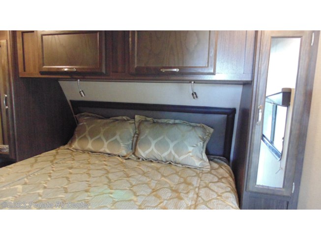 Cozy RV rental bedroom featuring a comfortable bed, convenient overhead storage cabinets, and reading lights for a relaxed stay.. Winnebago Spyder Toy Hauler 2020