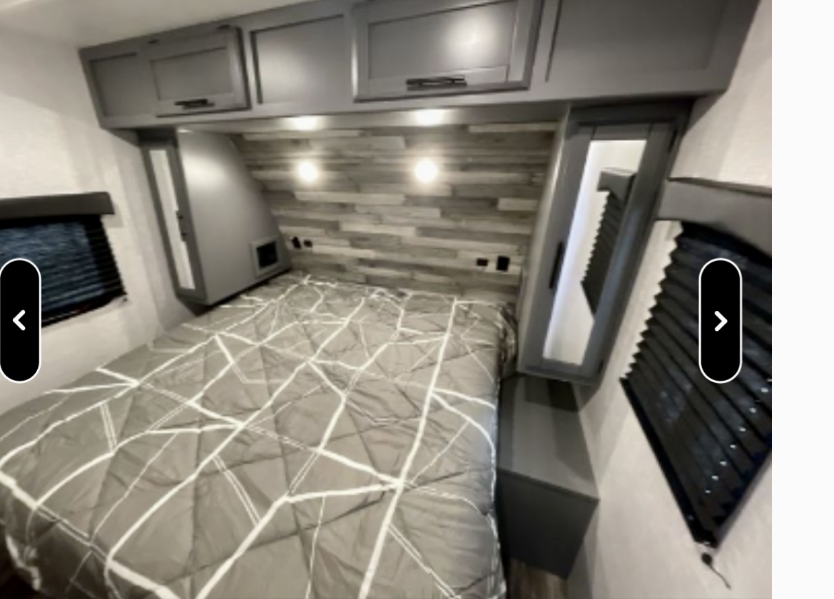 Cozy RV rental bedroom with a comfy bed, stylish headboard, and overhead cabinets for storage during your travels.. Crossroads RV Volante 2021