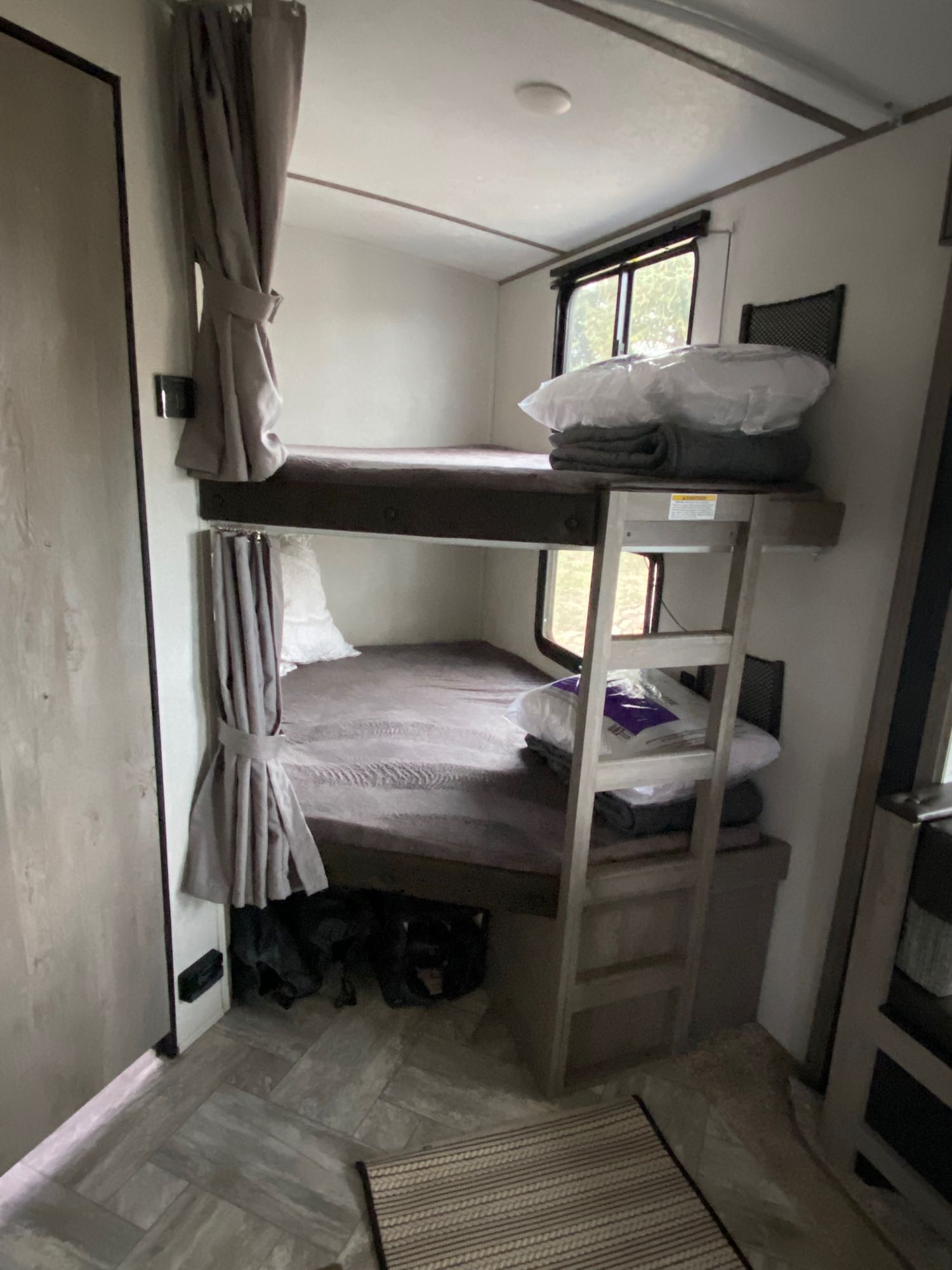 Interior of an RV rental with stacked bunk beds, providing compact sleeping space for travelers.. Keystone Springdale 2021