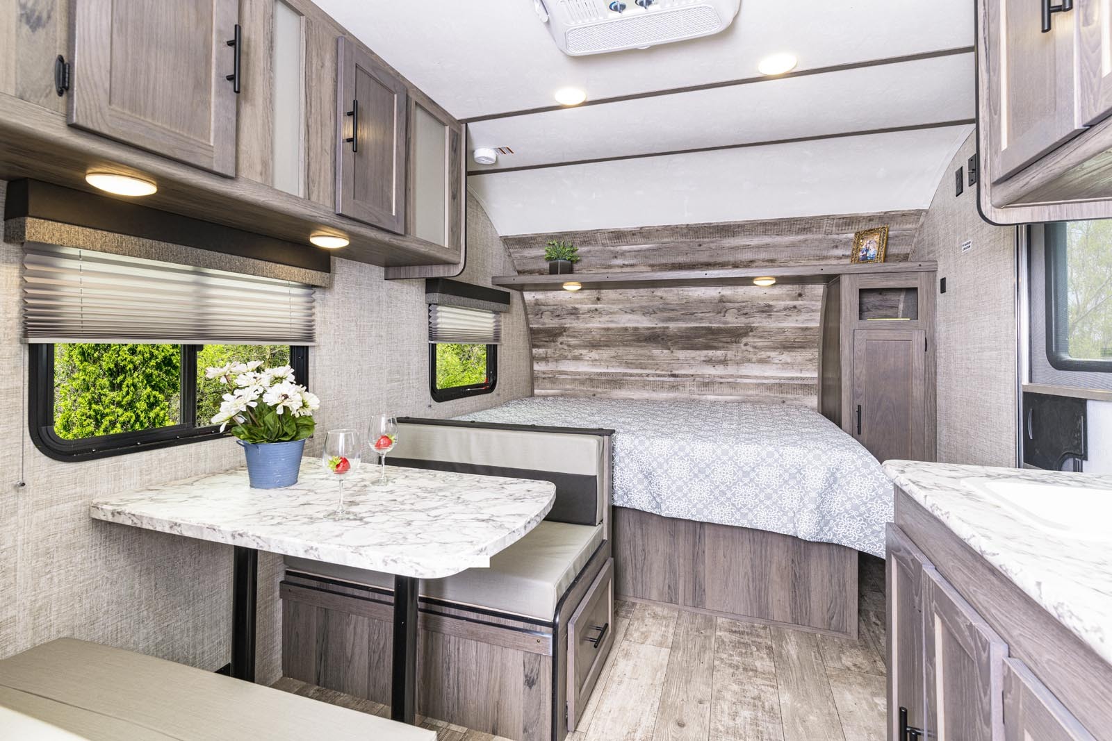 Spacious RV rental interior features a cozy bedroom, dining area with a table, and a functional kitchenette, ideal for travels.. Gulf Stream Ameri-Lite Super Lite 2022