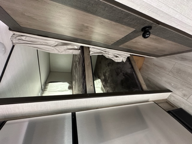 RV rental interior: A wooden cabinet sits above two tidy bunk beds, providing sleeping and storage solutions.. Surveyor Legend 19MDBLE 2022
