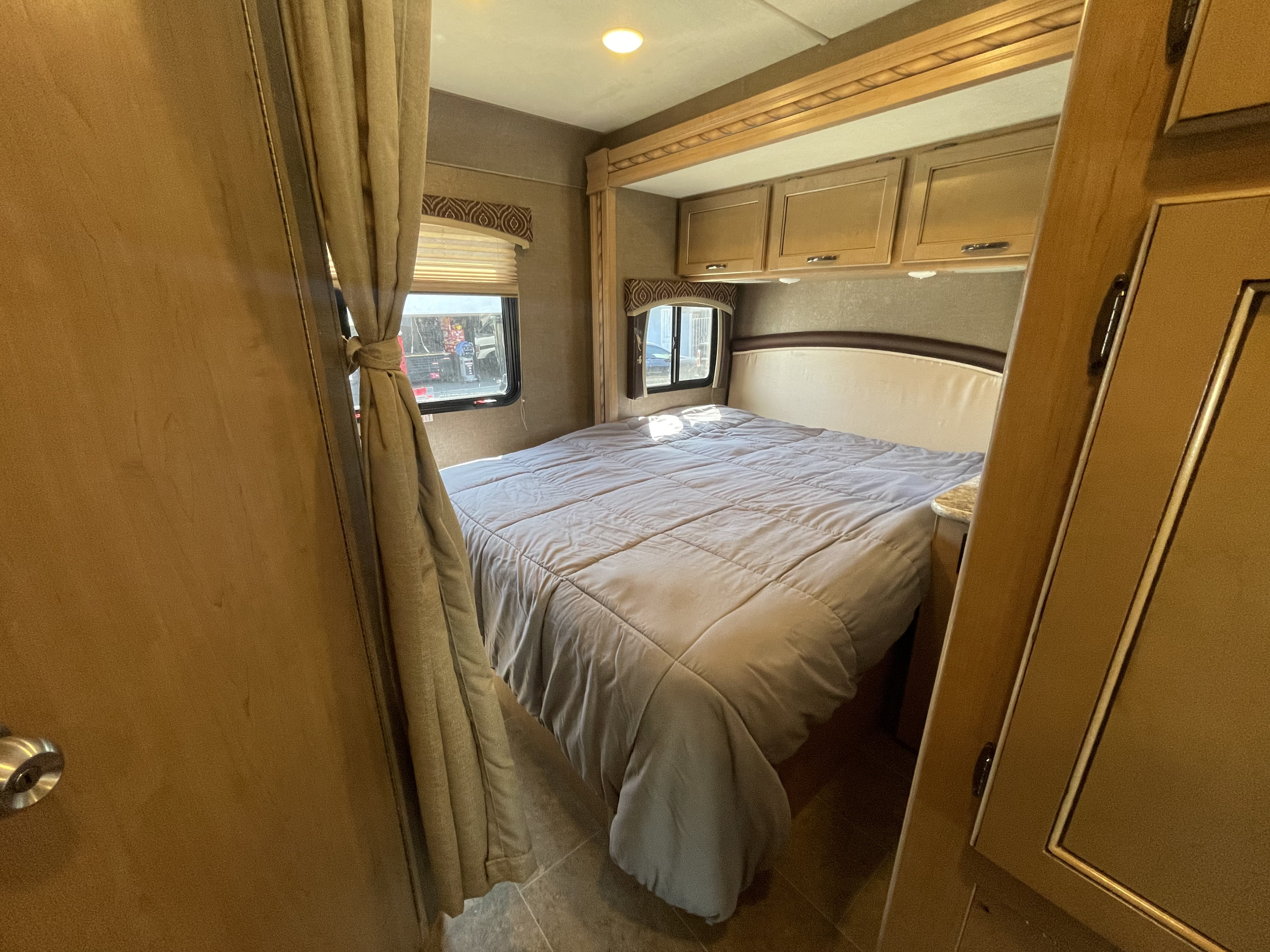 Cozy RV rental bedroom with a comfy bed, overhead cabinets, and windows. Perfect for your next adventure!. Other Chateau 2018