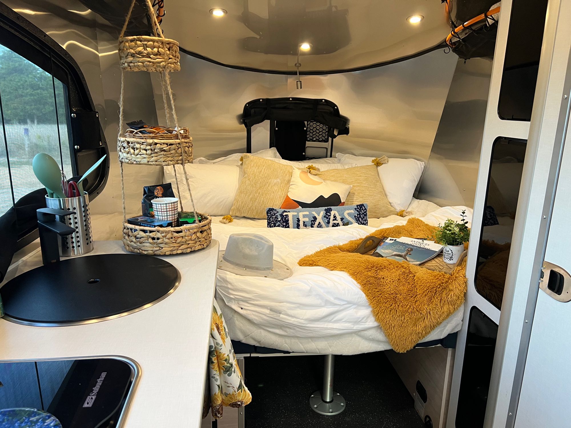 Cozy king size bed with mattress topper . Airstream Basecamp 2022