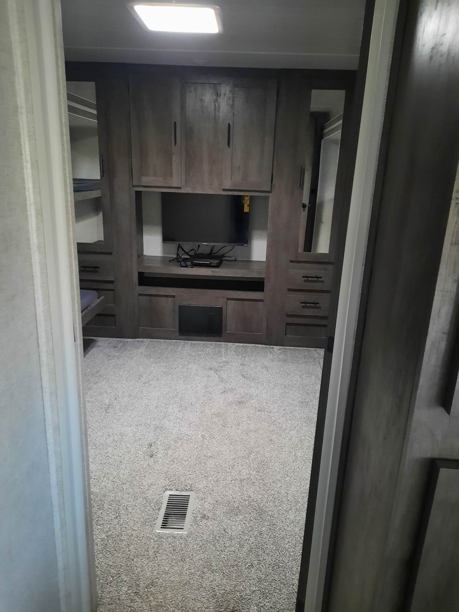 Spacious RV rental bunkhouse with TV, storage, and cozy carpet, perfect for family travel.. Forest River Wildwood 2021