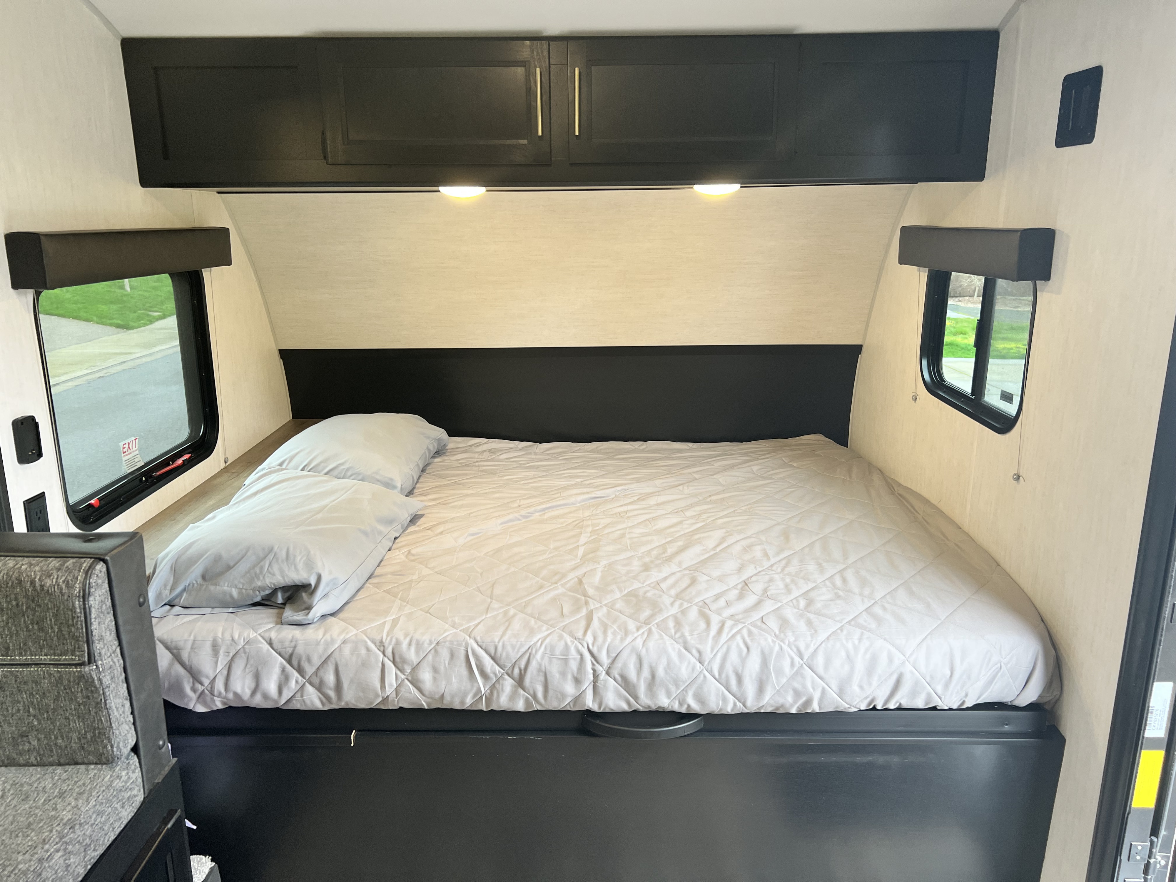 RV rental: Cozy bedroom with a large bed, overhead storage, and side windows. Ideal for comfortable travel.. Cherokee Wolf Pup #2 17jg 2023