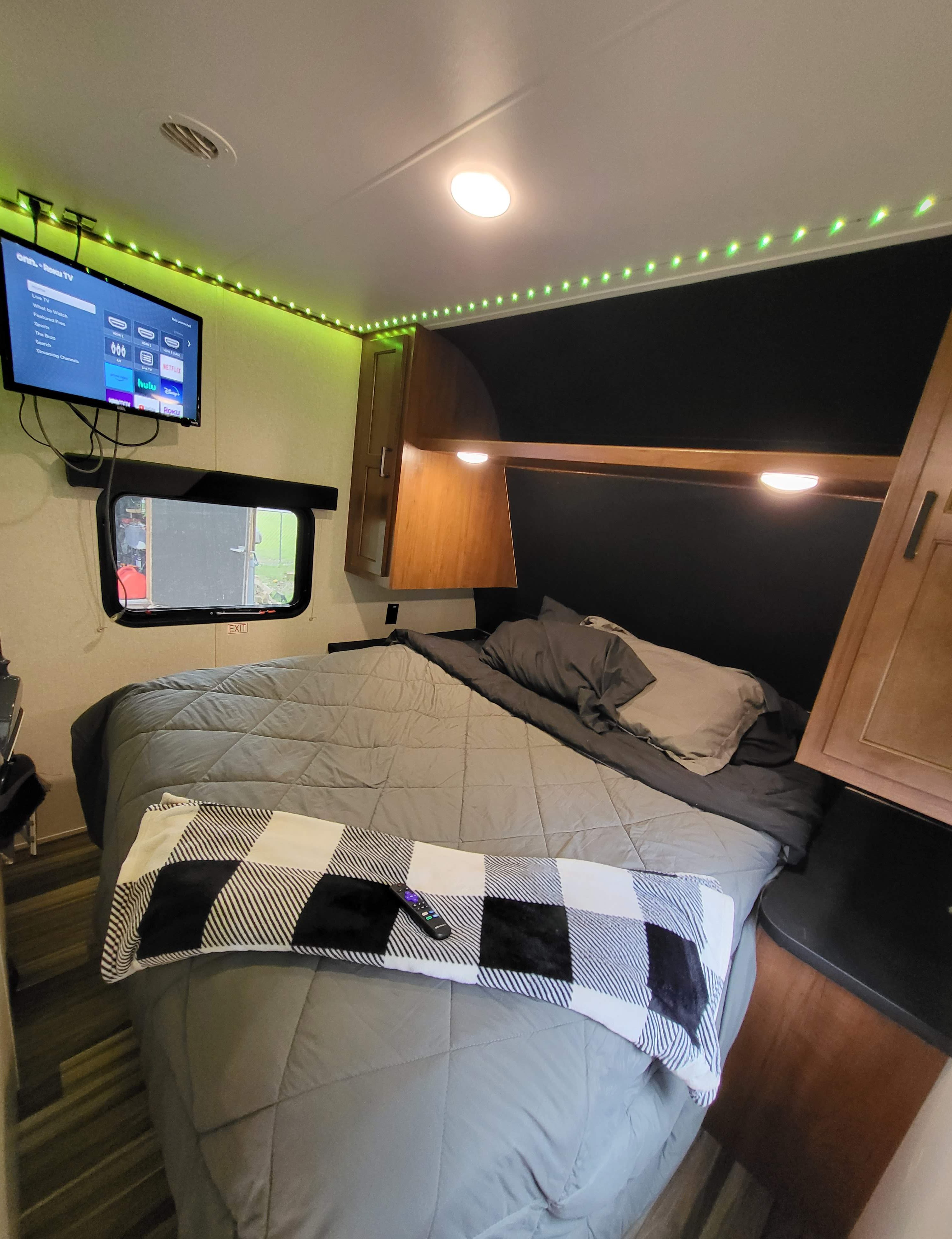 Cozy rv rental bedroom featuring a mounted TV, bed with blanket, and overhead green LED lighting for comfort.. Jayco Jay Flight SLX 2017