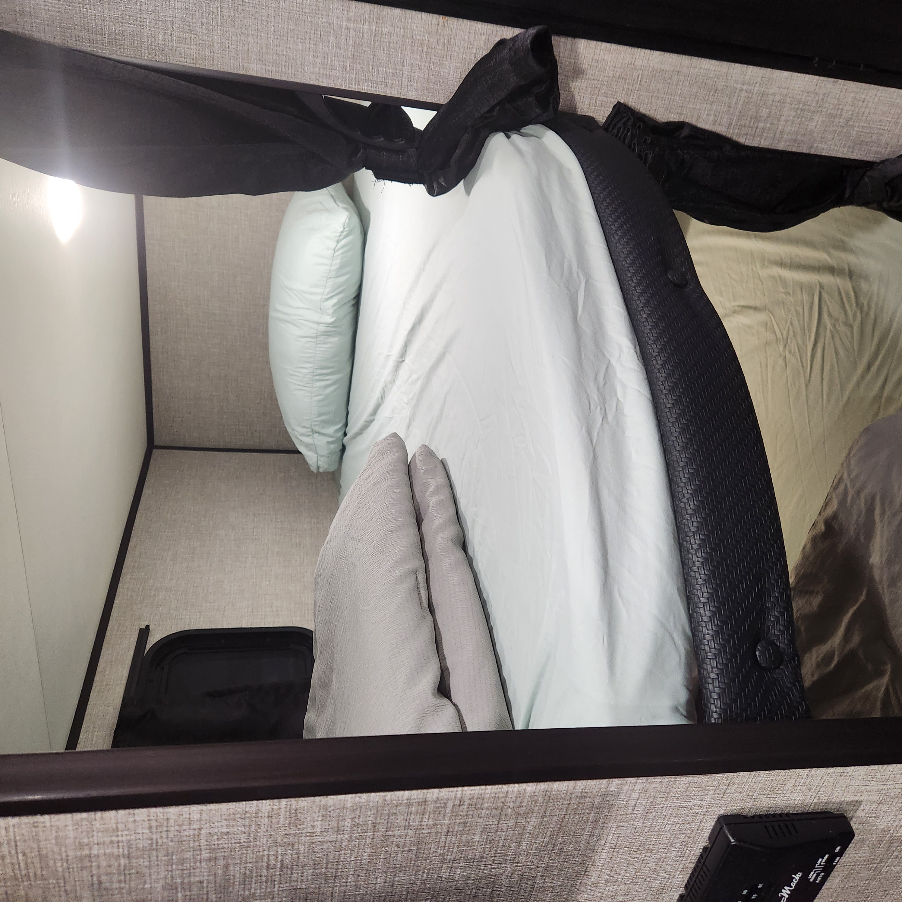 Overhead view of a comfortable RV rental bedroom, with a light blue bed, pillows, and textured walls providing a cozy sleeping area.. Jayco 264bhw 2023