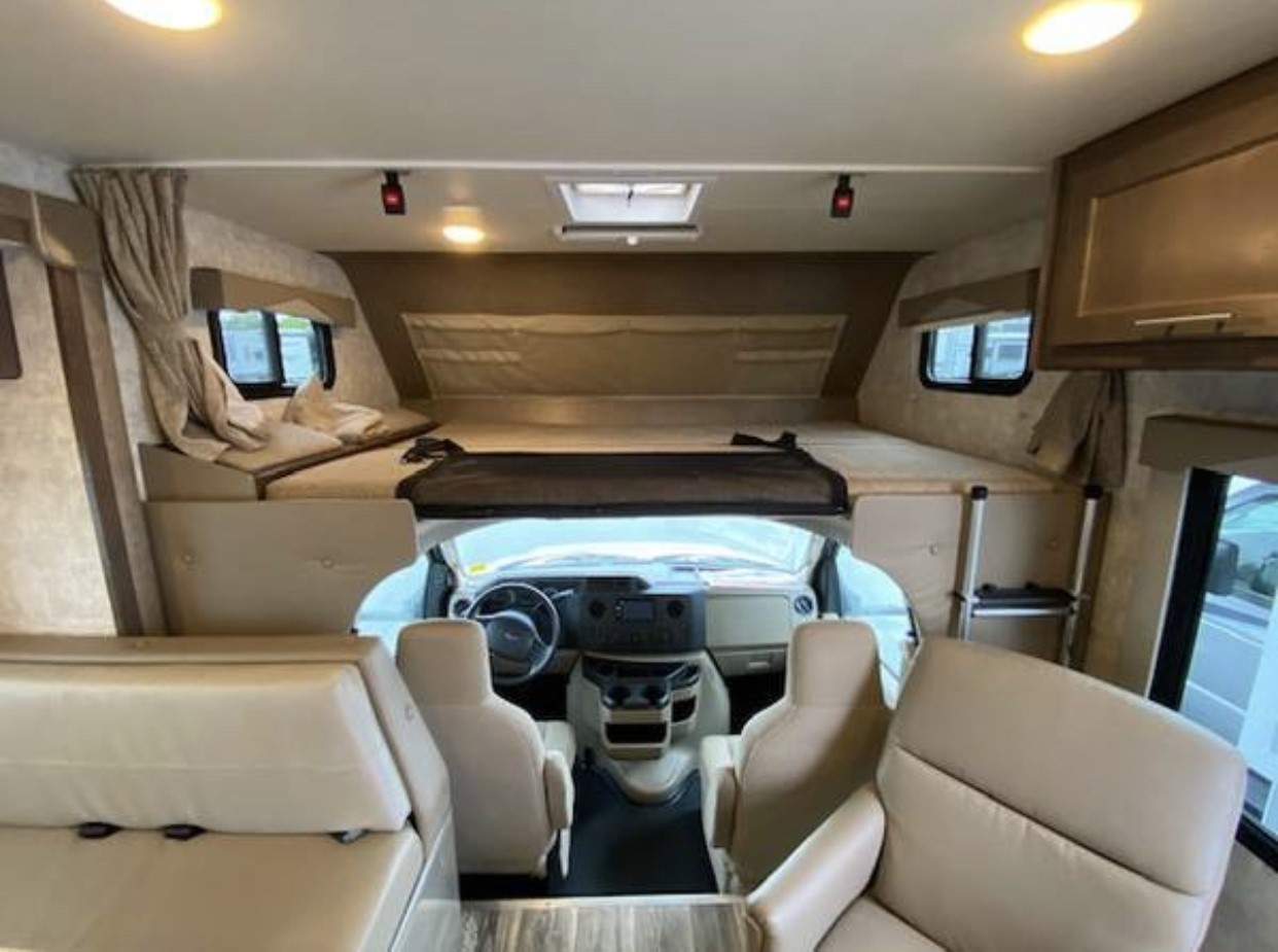 Inside a comfortable RV rental, showing the front cockpit, a large cab-over bed, and the living area.. Adventurer Adventurer class C 2018