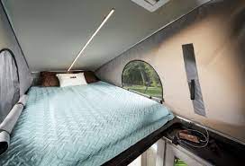 This RV rental's pop-top bed offers a comfy sleeping area with side windows and a ceiling light.. Roadtrek Zion Slumber 2022