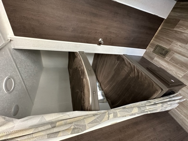 An RV rental's interior bunk beds are shown, with two brown mattresses folded vertically to reveal a lower area, perfect for small spaces.. Salem 26DBLE 2019