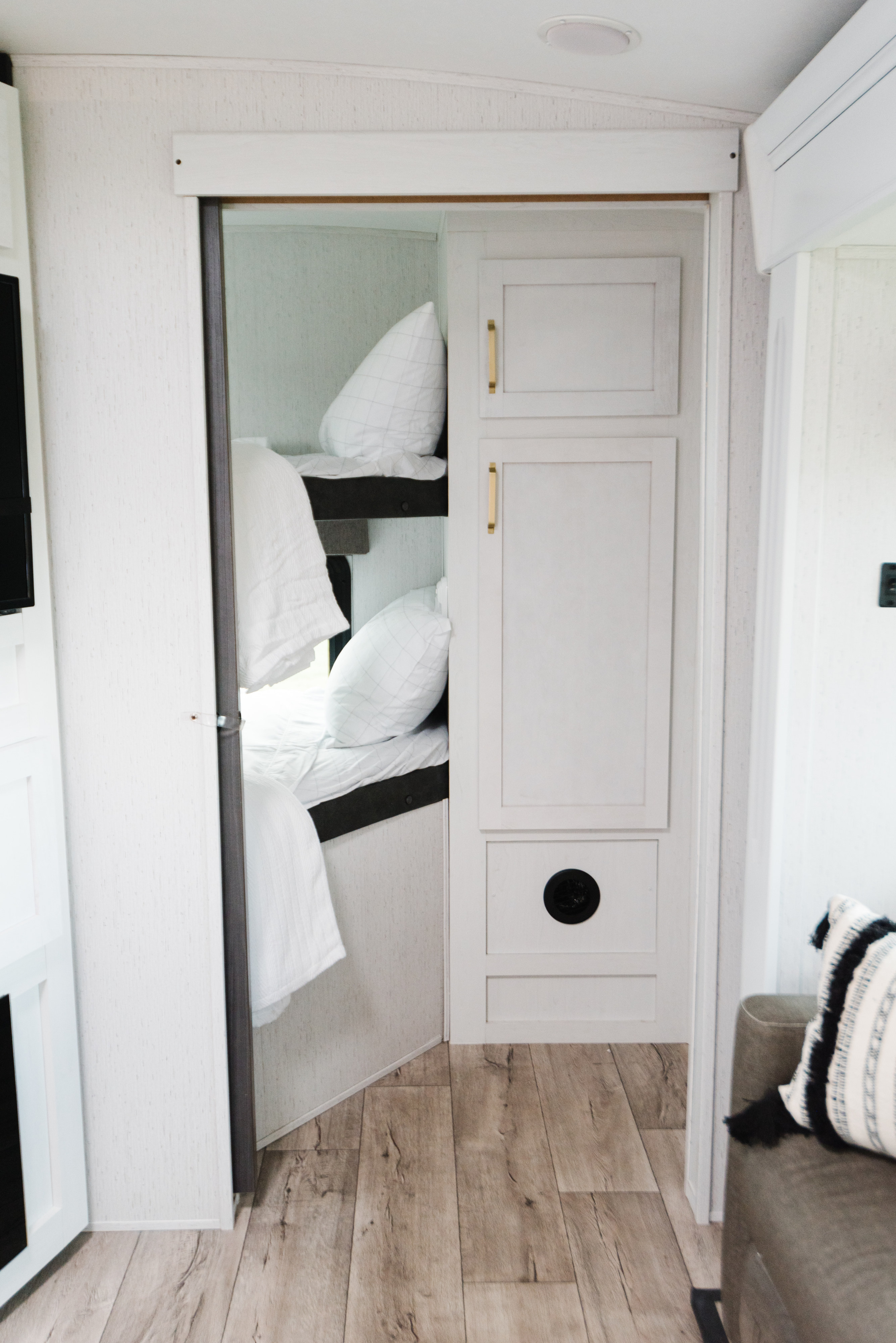 Clean RV rental interior with bunk beds, white bedding, and sleek cabinetry. Ideal for travel.. Dutchmen Astoria 2022