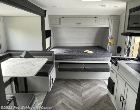 RV rental interior: light-colored modern space with a dinette, bed, overhead cabinets, and compact kitchen.. Forest River Salem FSX 178bhsk 2023