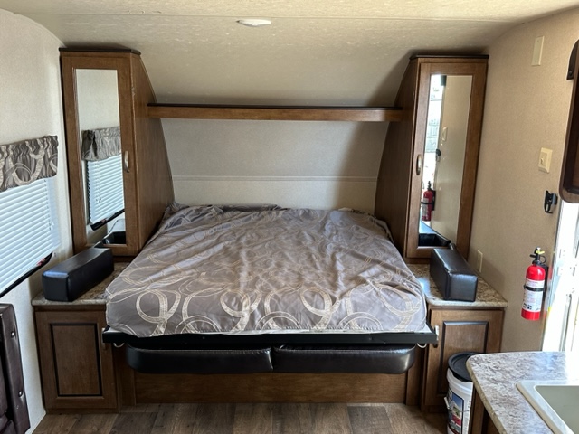Comfortable RV rental bedroom with a queen bed, mirrored wardrobes, and side storage.. Wildwood X-Lite 230BHXL 2018