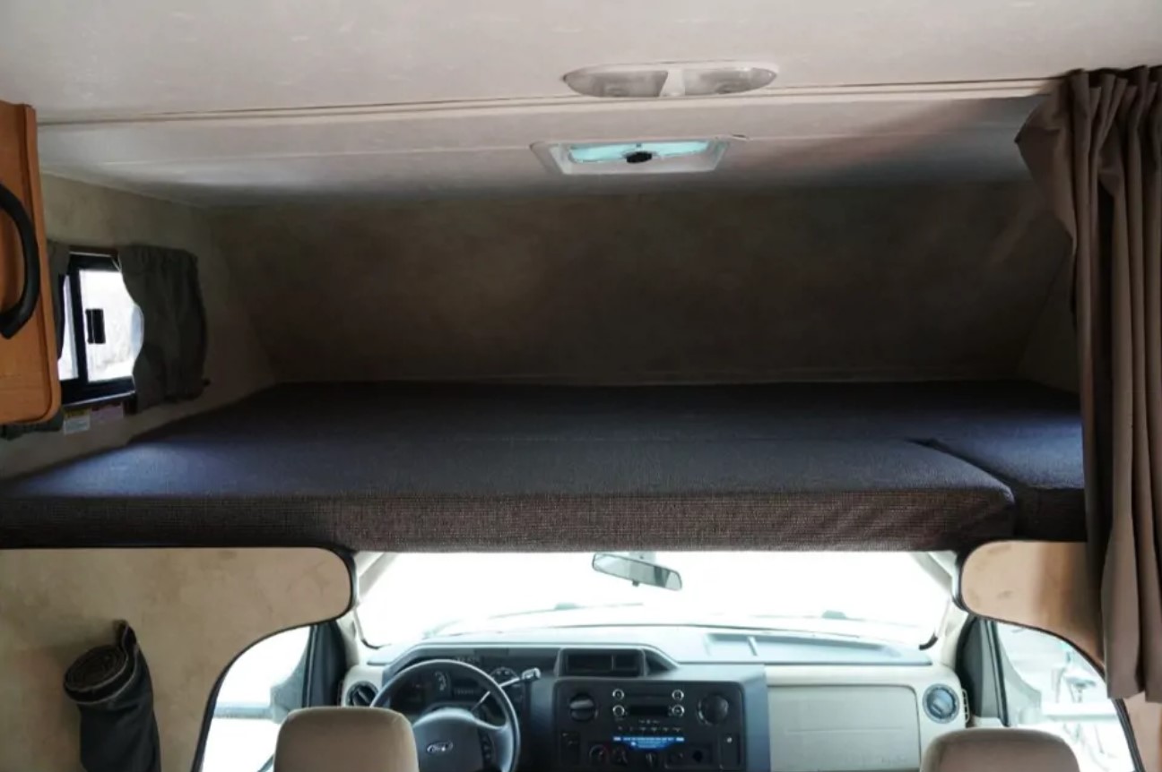 Interior of an RV rental, featuring the cab-over bunk bed and the driver's cockpit. Ideal for your next road trip adventure.. Thor Majestic 2012
