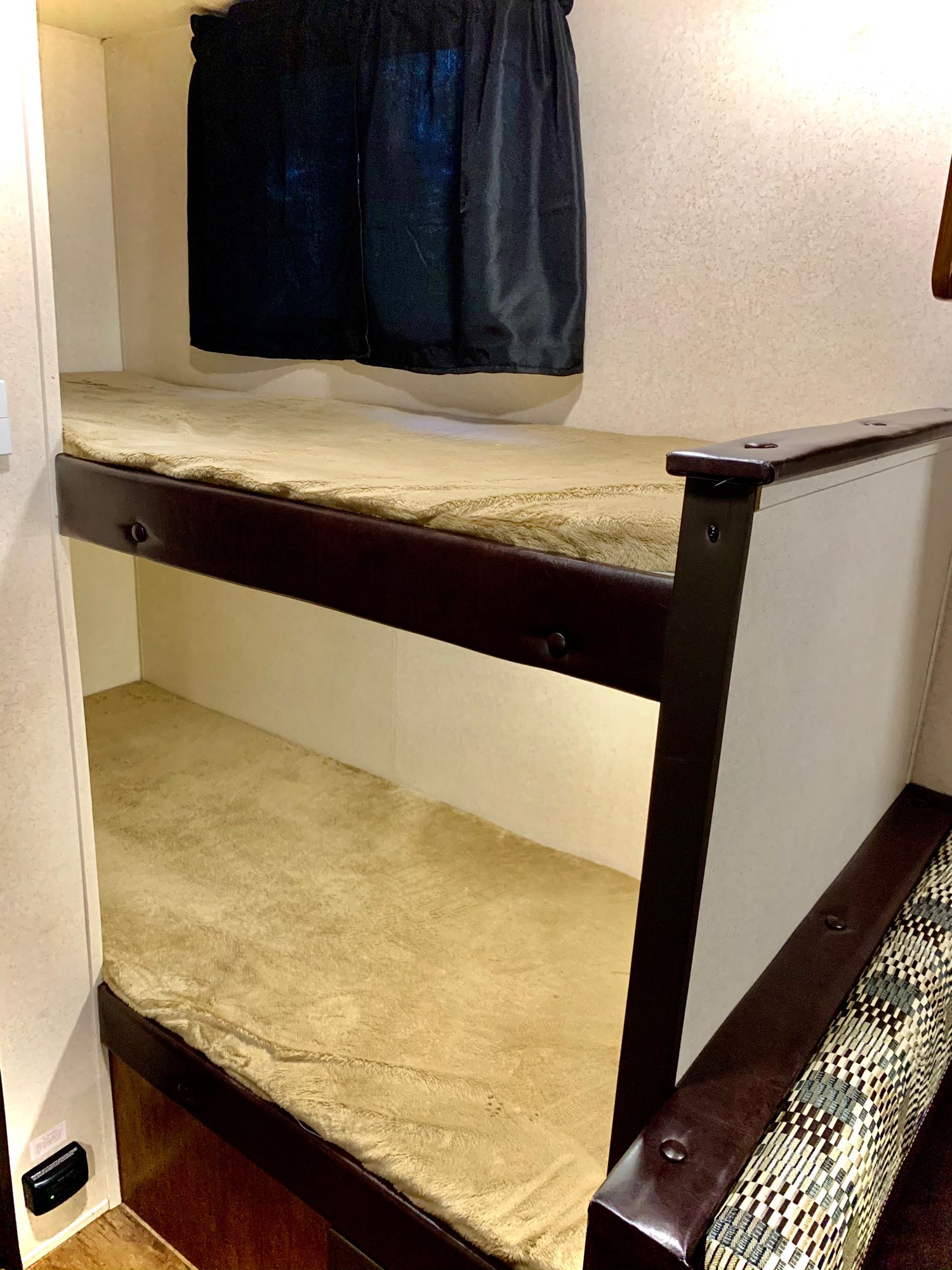 Comfortable bunk beds for your next RV rental adventure. Plush mattresses and privacy curtains create a cozy sleeping space.. Forest River Wildwood X-Lite 2018