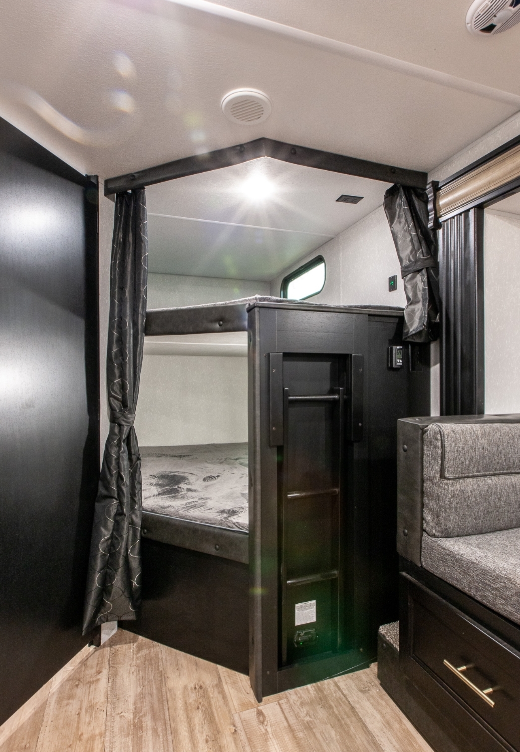 Modern RV rental interior: bunk beds with privacy curtains, integrated ladder, and comfy seating. Perfect for family trips.. Forest River Cherokee Grey Wolf 2022