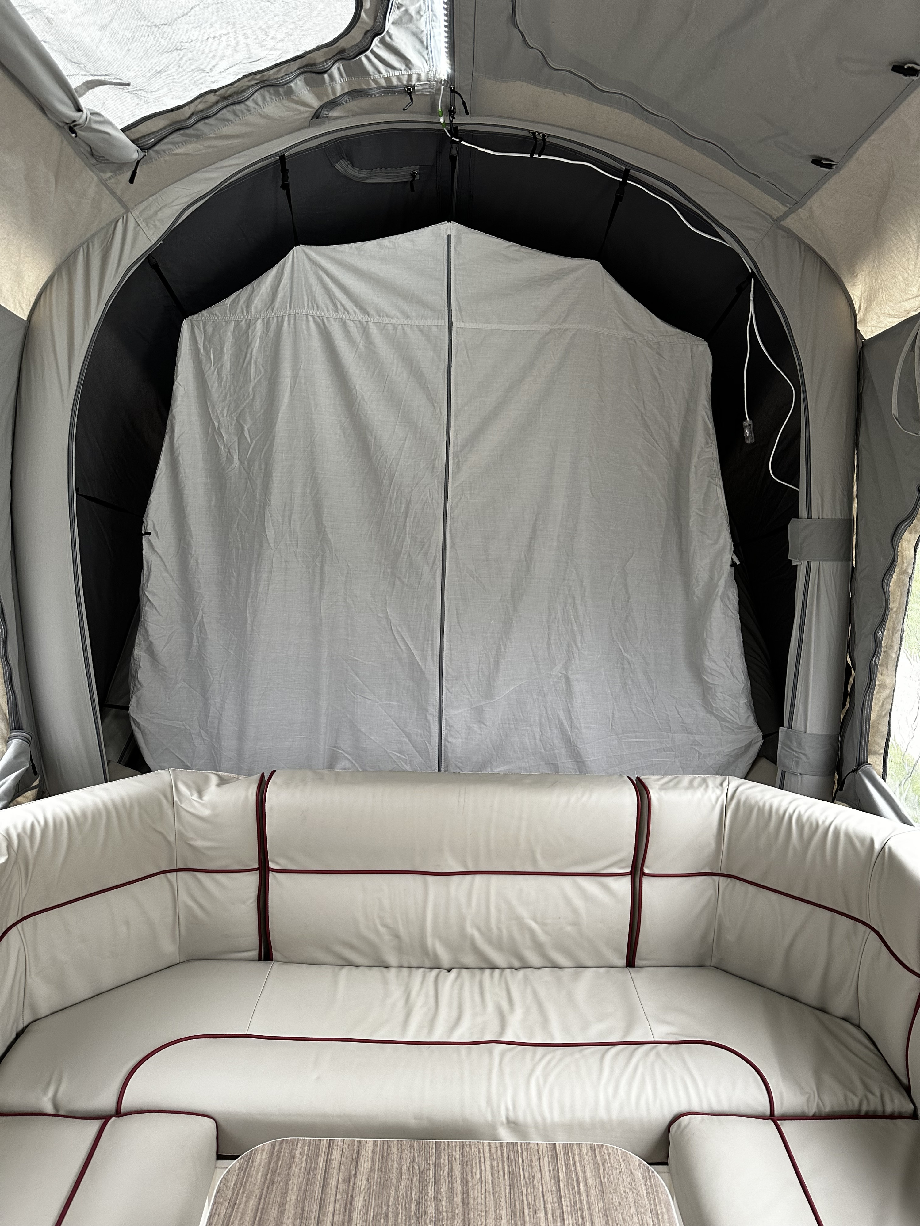 Step inside this cozy RV rental with comfortable light-colored seating and an extendable grey fabric enclosure for privacy.. Other Other 2022