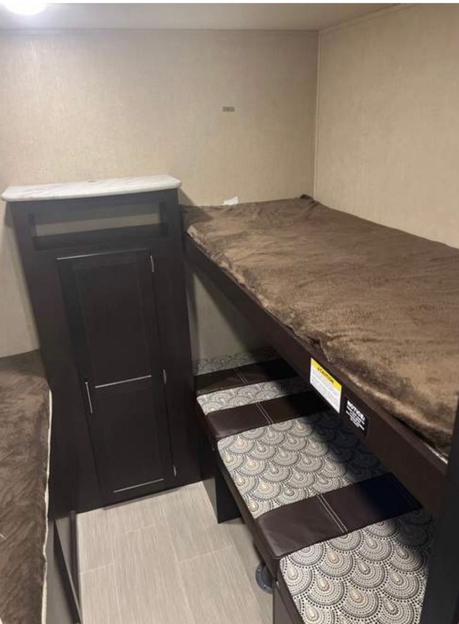 RV rental interior featuring bunk beds with plush blankets, a sleek storage cabinet, and stylish floor.. Dutchmen Kodiak Express 2018