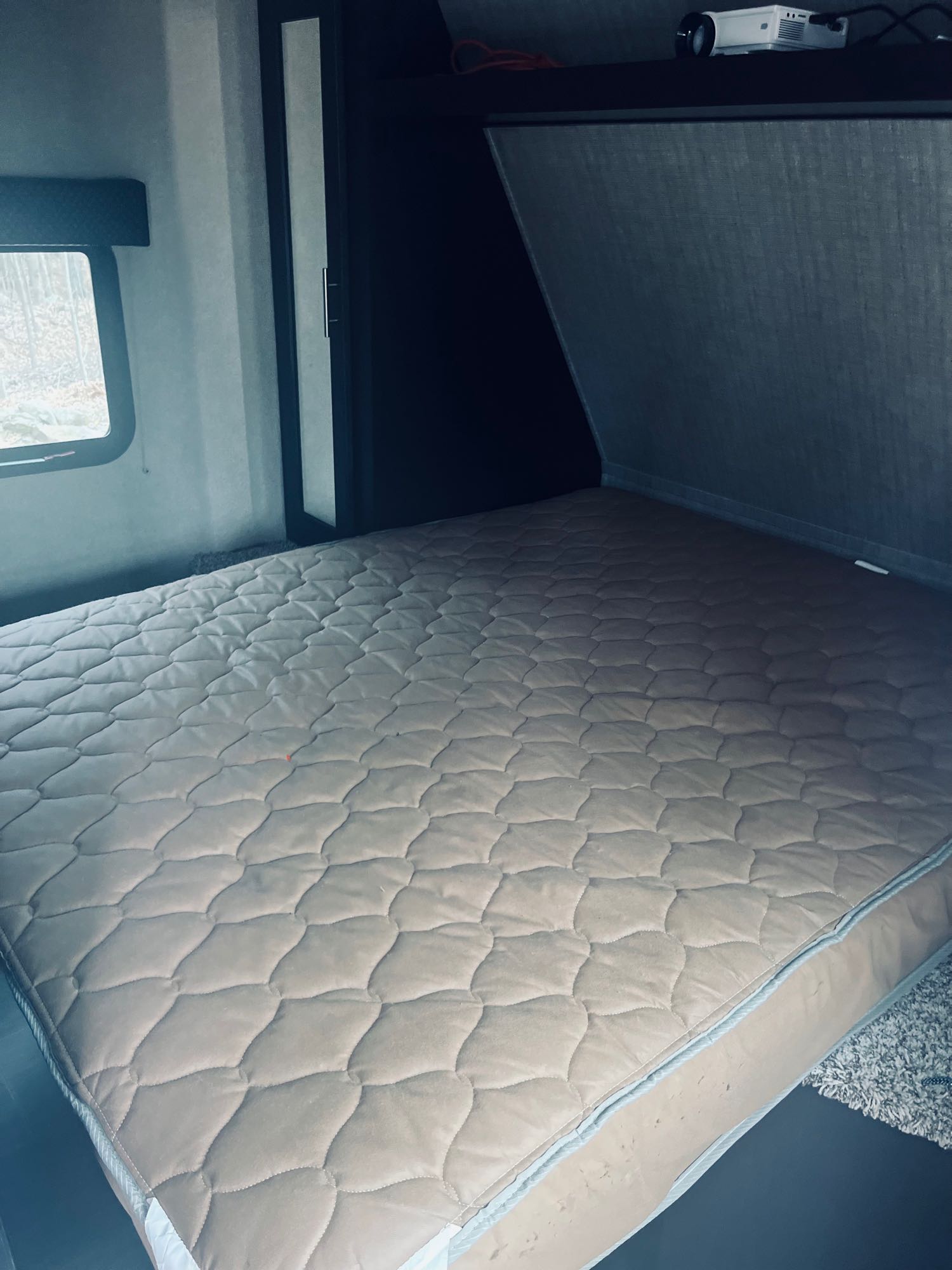 RV rental bedroom features a comfortable quilted mattress, window view, and overhead projector for entertainment.. Dutchmen Kodiak Express 2018