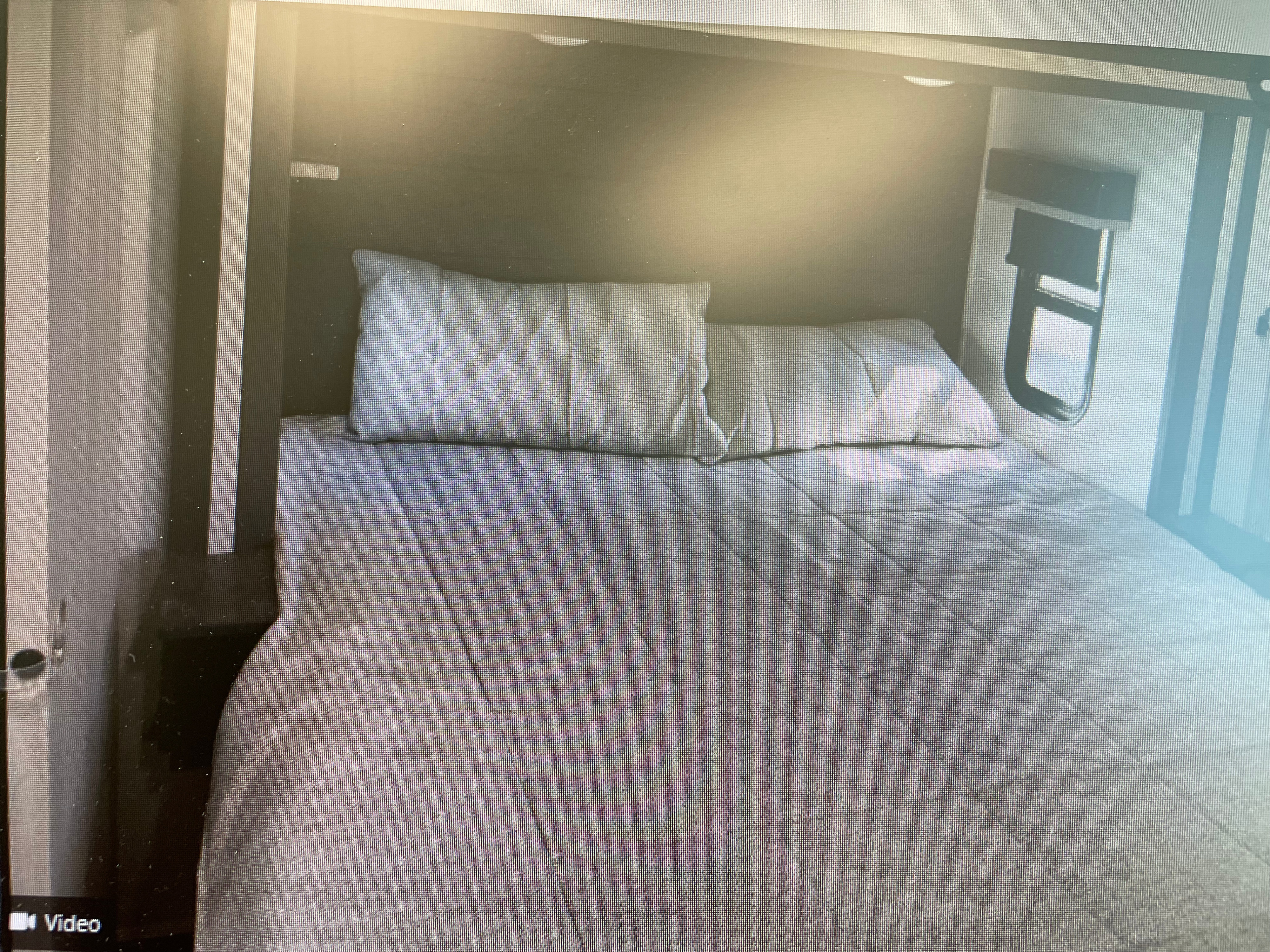 RV rental bedroom view: a neatly made bed with two grey pillows and a quilted comforter in a compact RV interior.. Keystone Fuzion 2021