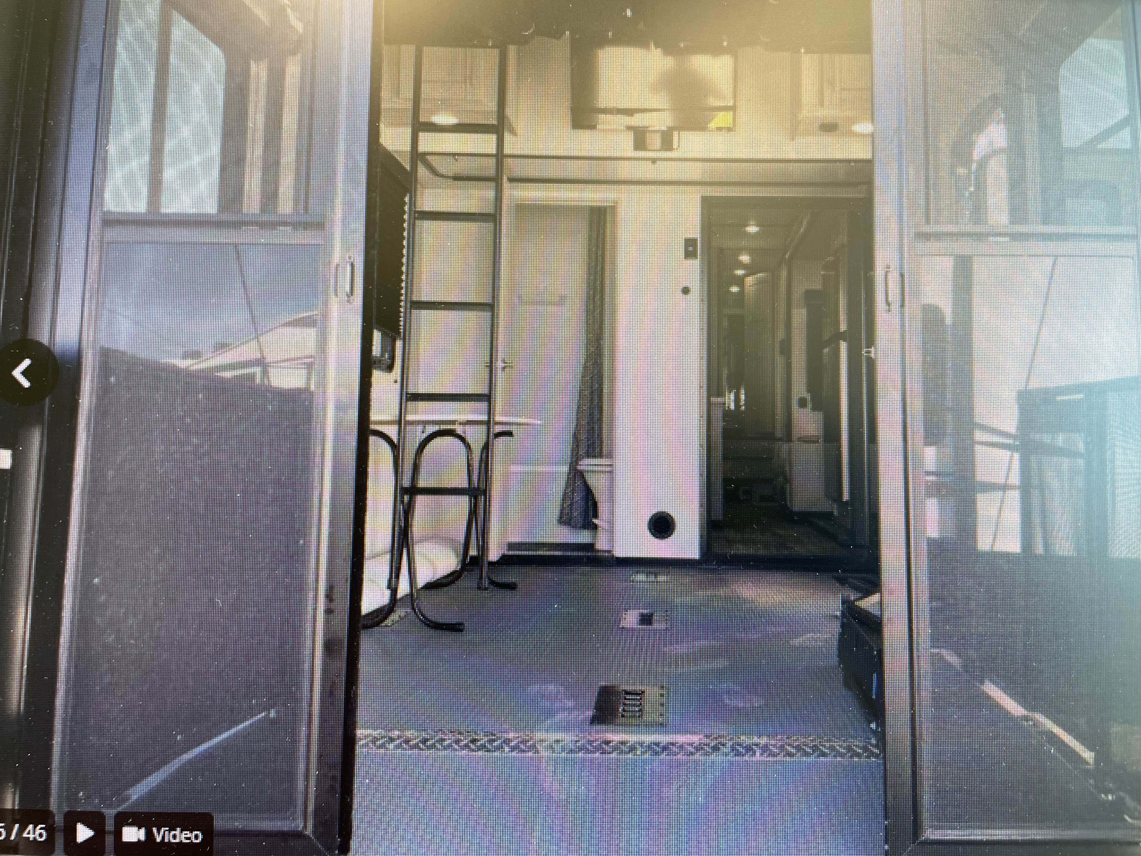 RV rental toy hauler interior, showing open ramp, ladder, and spacious garage area with diamond plate floor.. Keystone Fuzion 2021