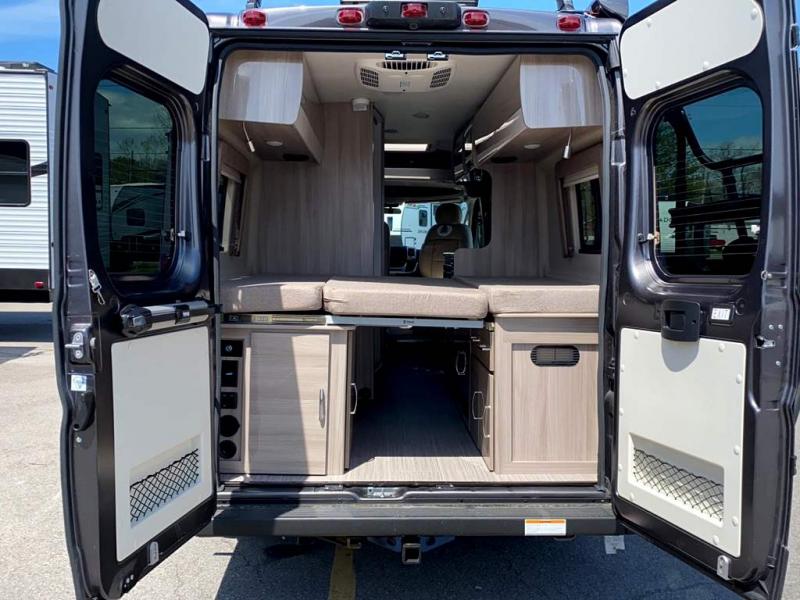 Spacious rv rental interior from the rear, doors open to reveal a convertible bed and storage. Ideal for comfortable mobile home travel.. Thor Sequence 2022