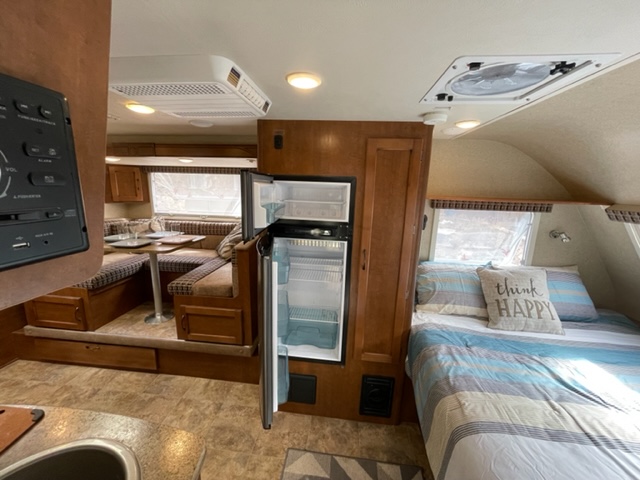 Cozy RV rental interior with kitchen, dinette, and bedroom, perfect for travel and compact living.. Lance Manufacturing Lance Manufacturing Trailer 2015