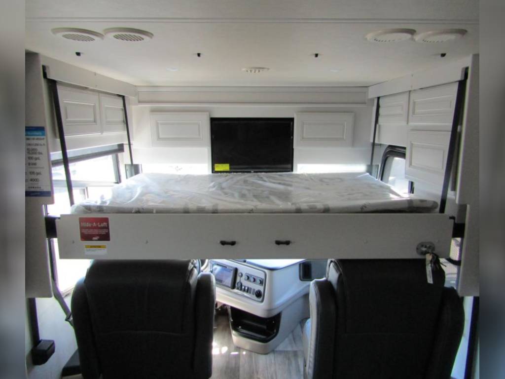 RV rental interior with a lowered bunk bed above the cab seats, offering extra sleeping space for your journey.. Holiday Rambler Armada 2023