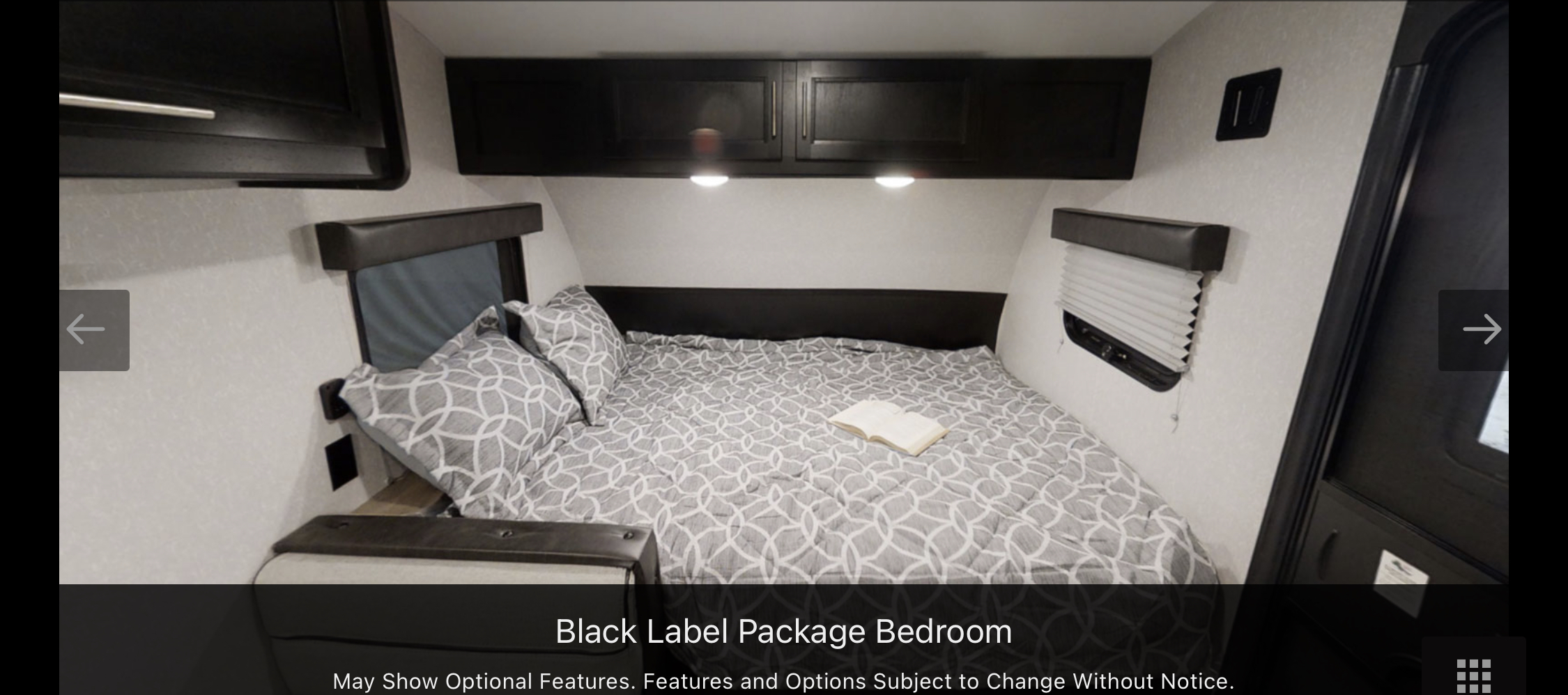 Cozy RV rental bedroom featuring a comfy bed with patterned bedding, overhead storage cabinets, and window blinds.. Forest River Cherokee Wolf Pup 2022