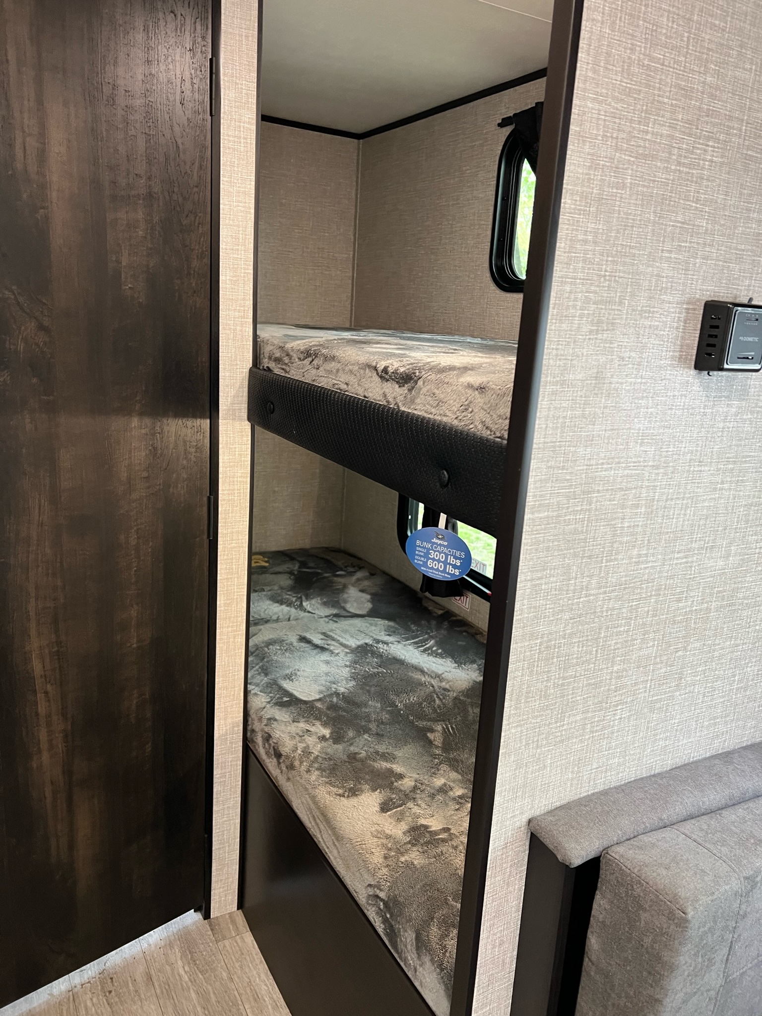 Cozy RV rental interior with bunk beds, ideal for family travel. Notice the bunk capacity warning.. Jayco Jay Flight SLX Baja Edition 2022