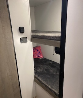 Inside this RV rental, find a cozy bunk bed sleeping area with two bunks, perfect for family travel.. Keystone Springdale 2021