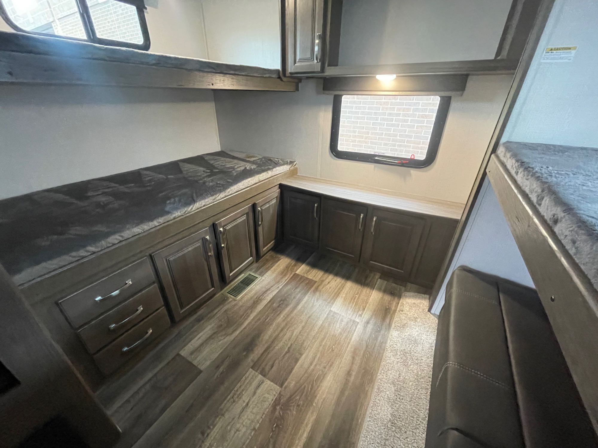 RV rental bunkhouse interior with upper & lower beds, window, ample cabinet storage, & wood-look flooring.. Keystone Cougar 2023