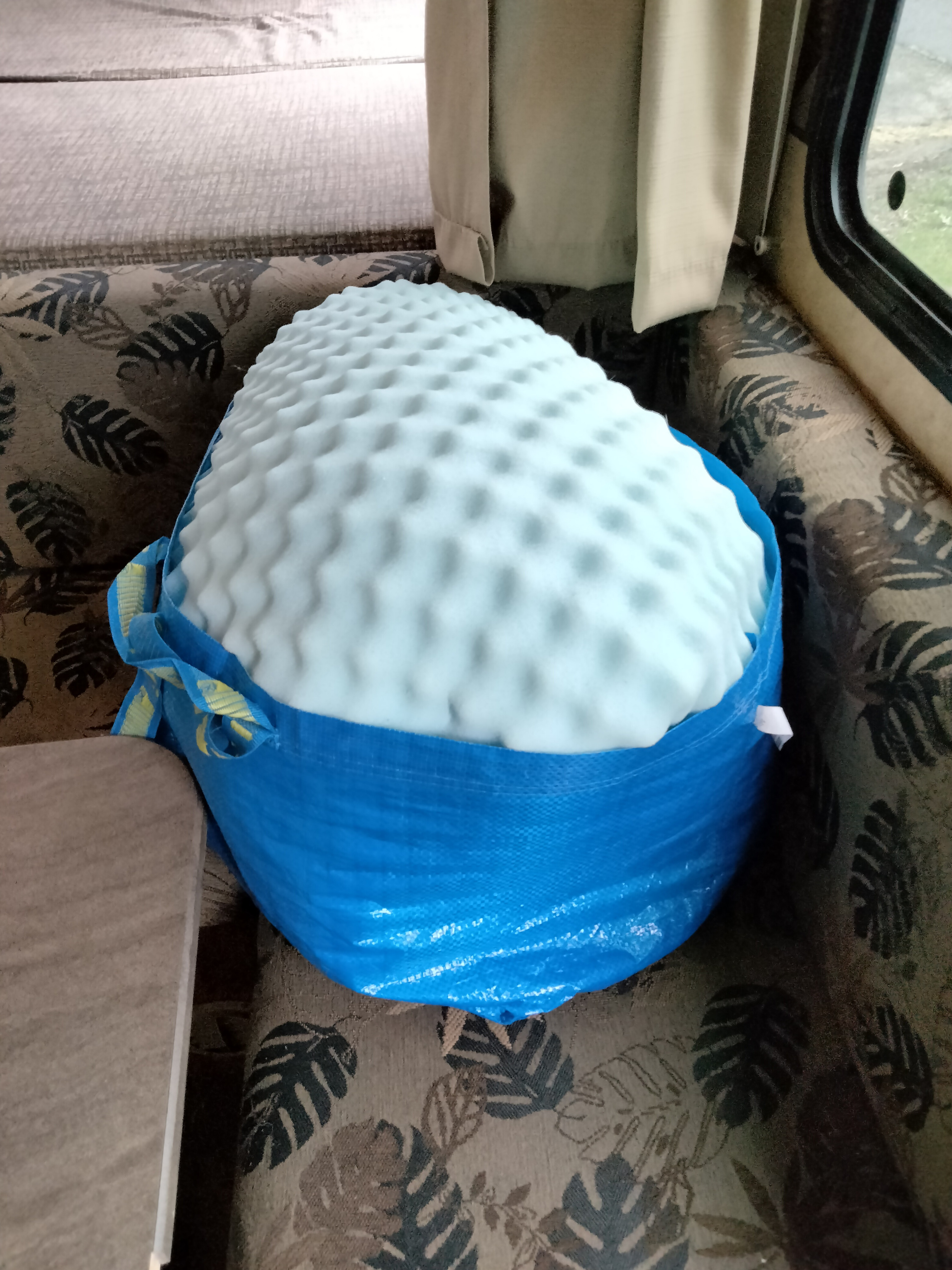 Light blue foam mattress topper, still in its blue IKEA bag, ready to enhance RV rental comfort.. Jayco Jay Feather Ultra Lite 2013