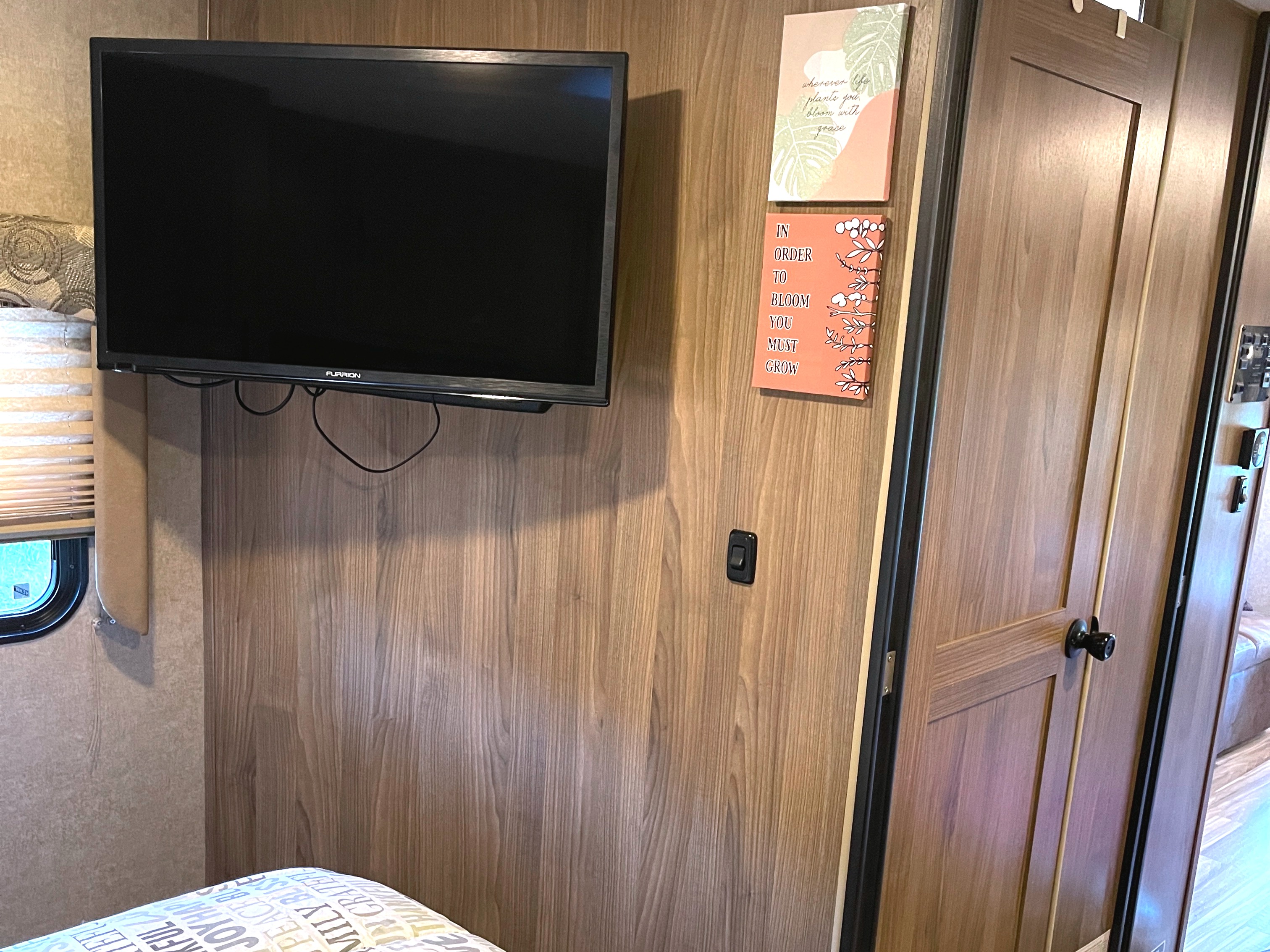 Enjoy a cozy RV rental interior featuring a mounted TV, modern wooden walls, and inspirational decor signs.. Other Other 2016