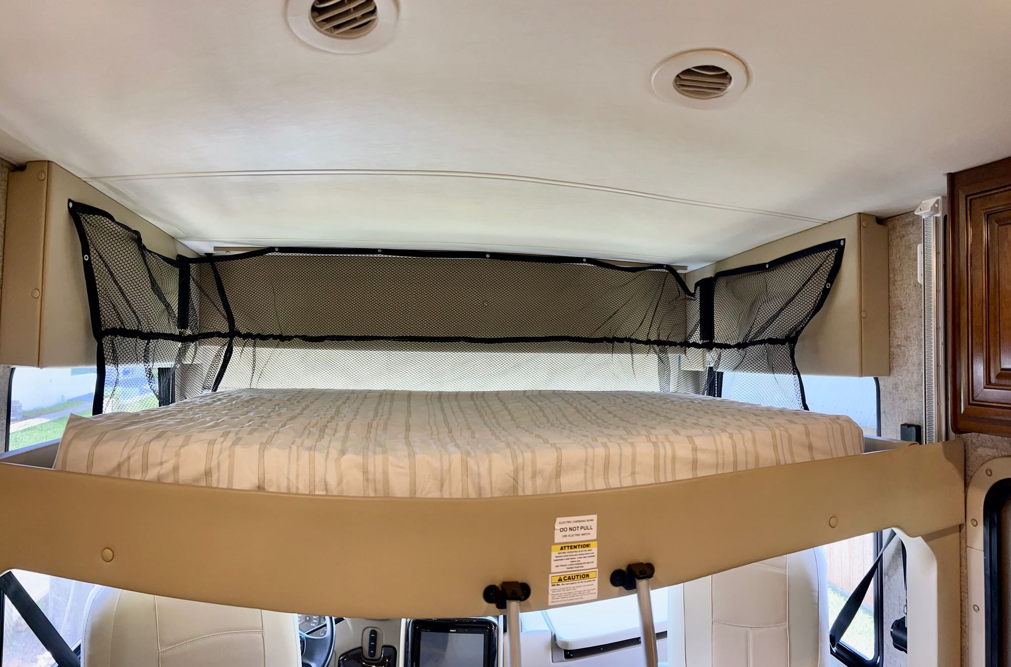 RV rental: Overhead bunk bed with mattress, safety net, and ceiling vents inside a motorhome.. Thor Miramar 2018