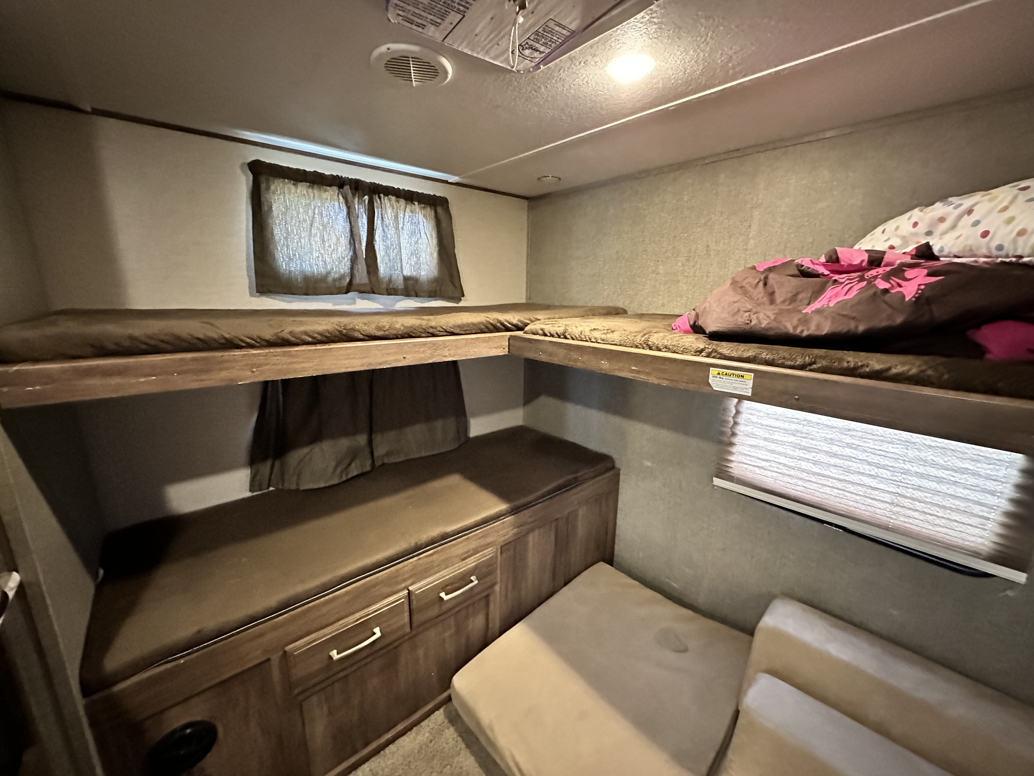 This cozy rv rental features a well-lit bunk bed area, complete with multiple sleeping berths, storage, and a comfy sofa.. Keystone RV Cougar 2018