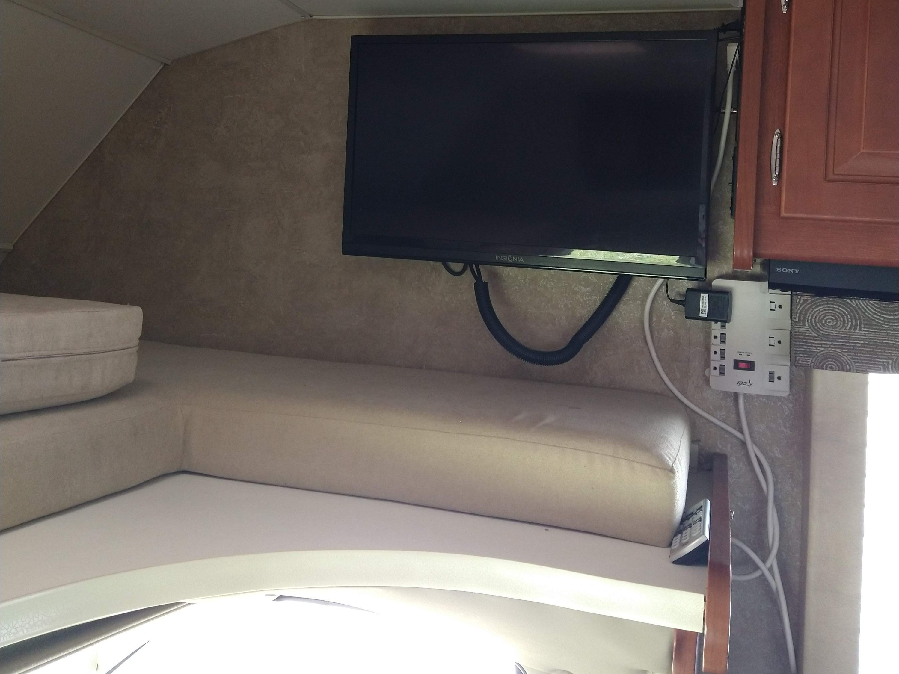 RV rental's cozy bunk area features a mounted TV and a convenient power strip for entertainment.. Winnebago Minnie Winnie 2015