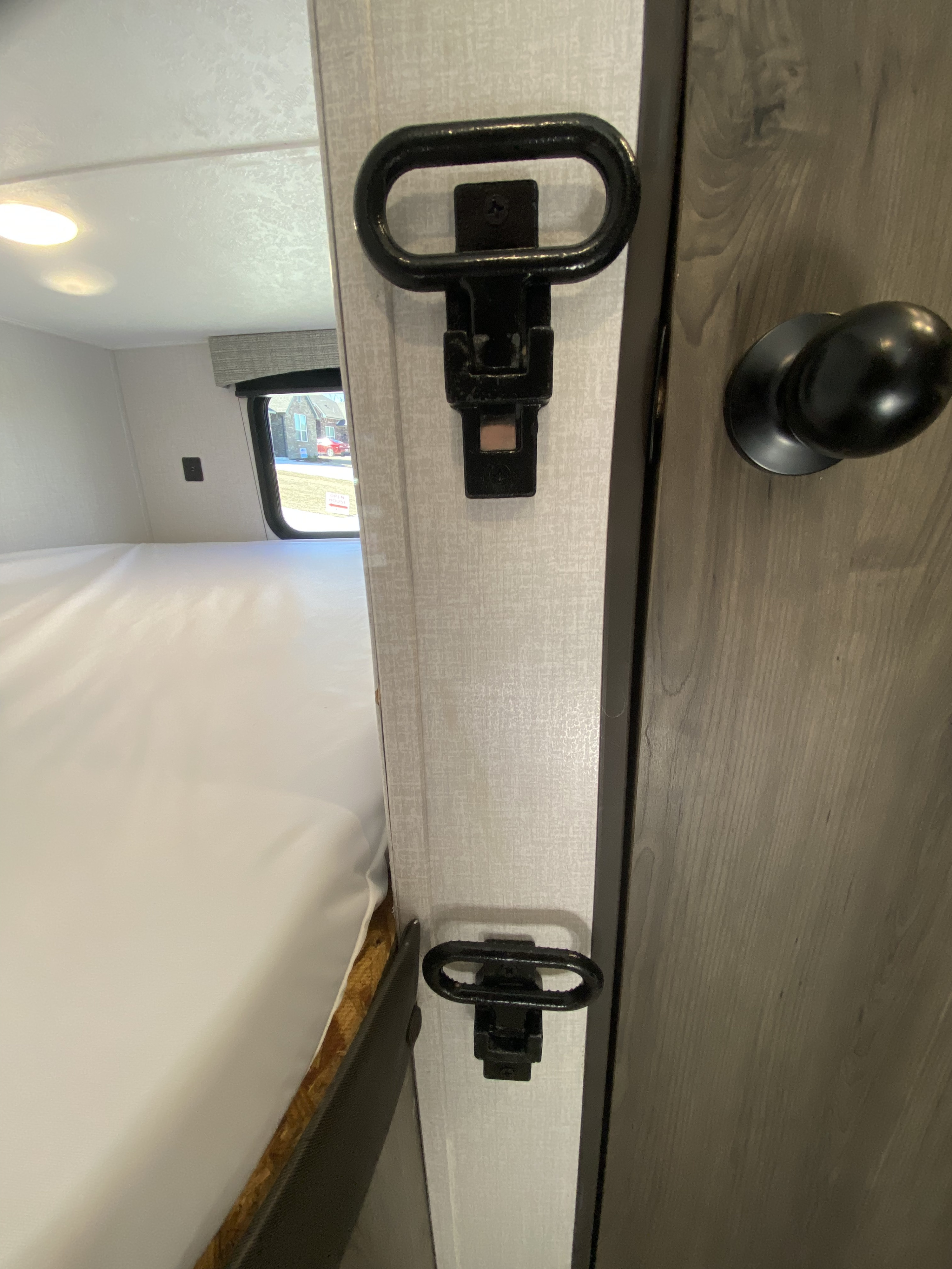 RV rental interior with bunk bed and two black steps. A dark door is on the right, and a window shows outside.. Forest River Coachmen Clipper 182DBU 2022
