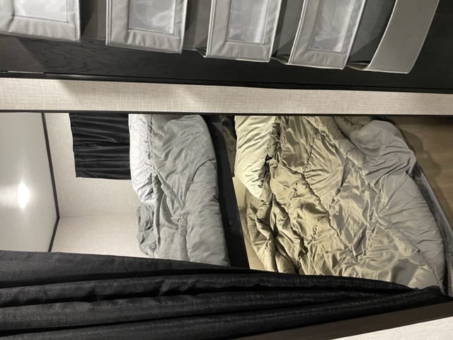 Inside this RV rental, two bunk beds with cozy bedding and privacy curtains offer a comfortable sleeping area.. Starcraft Autumn Ridge 2023