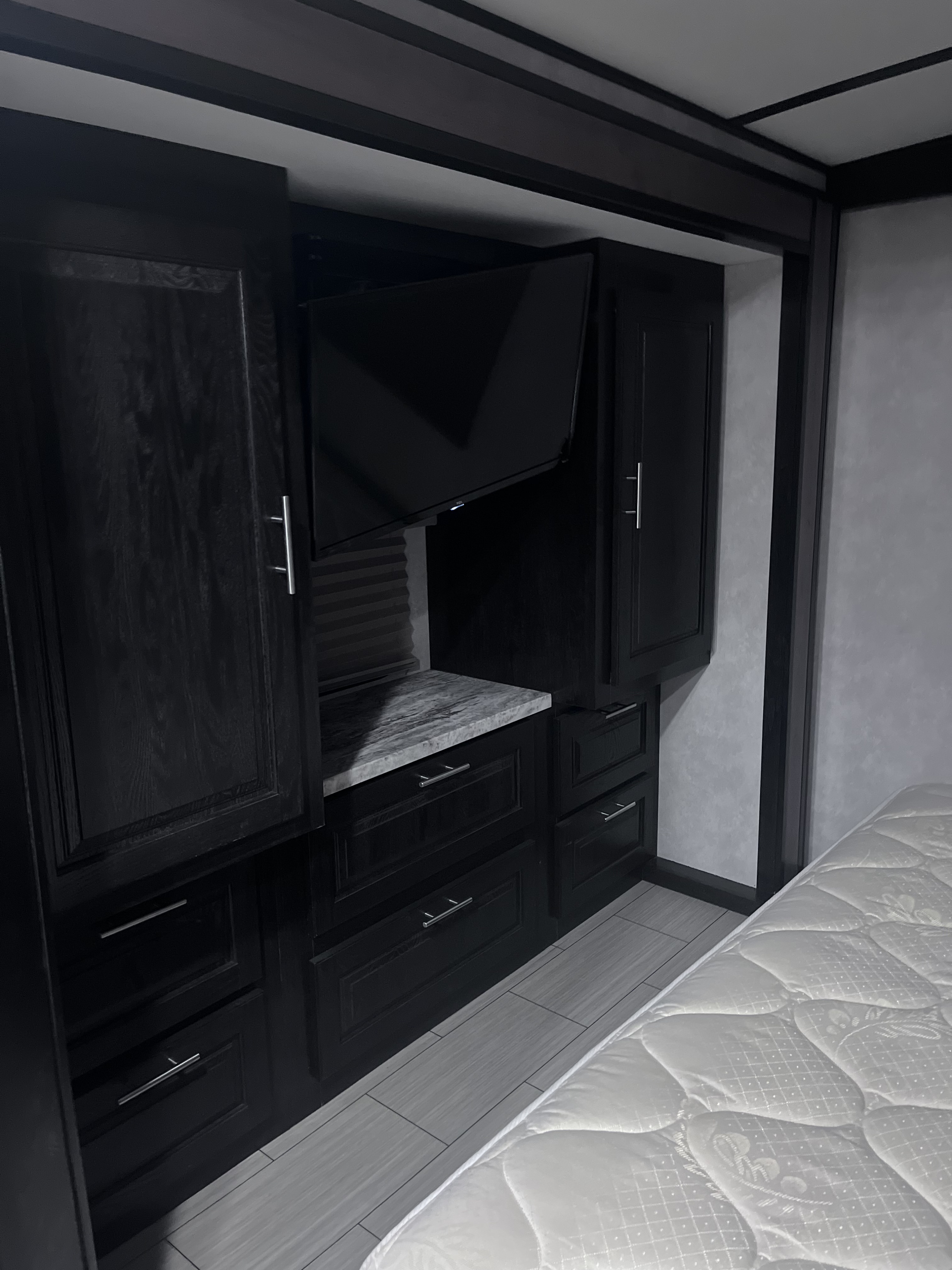 RV rental bedroom showcasing dark wood built-in storage, a mounted TV, and a white mattress for comfortable stays.. FR3 FR3 Motorhome 2019